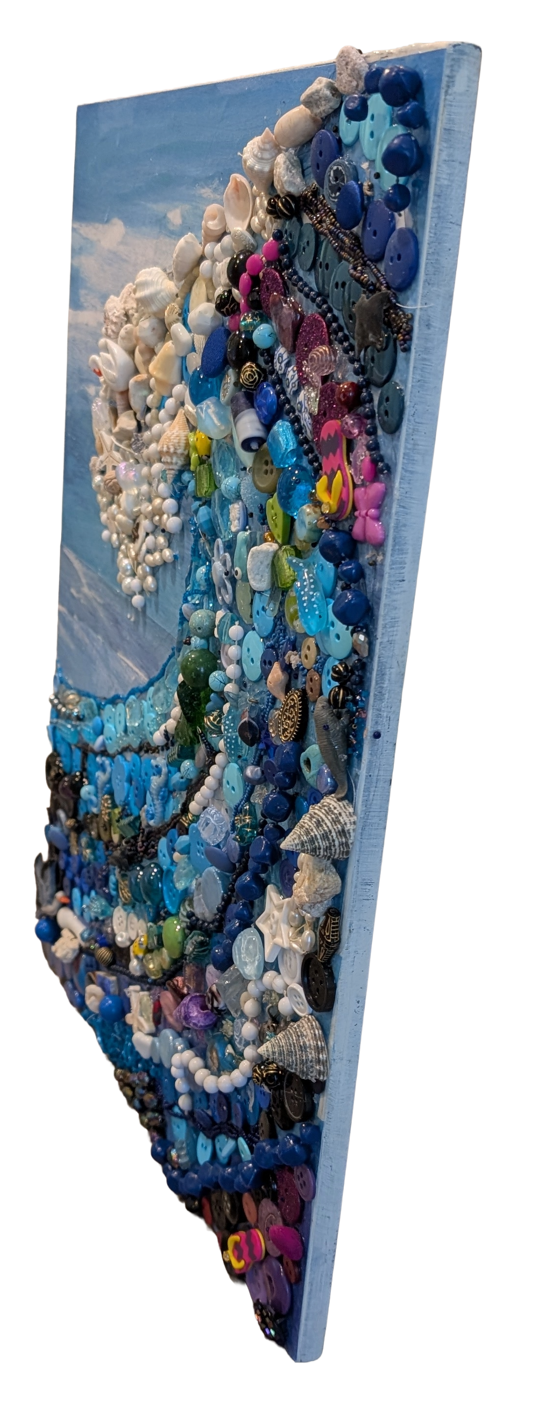 Right side angle view of Waves of Shells and Buttons Collage by Debbie Rich, emphasizing the detailed 3D texture, mixed-media construction, and side profile depth of the ocean wave collage.