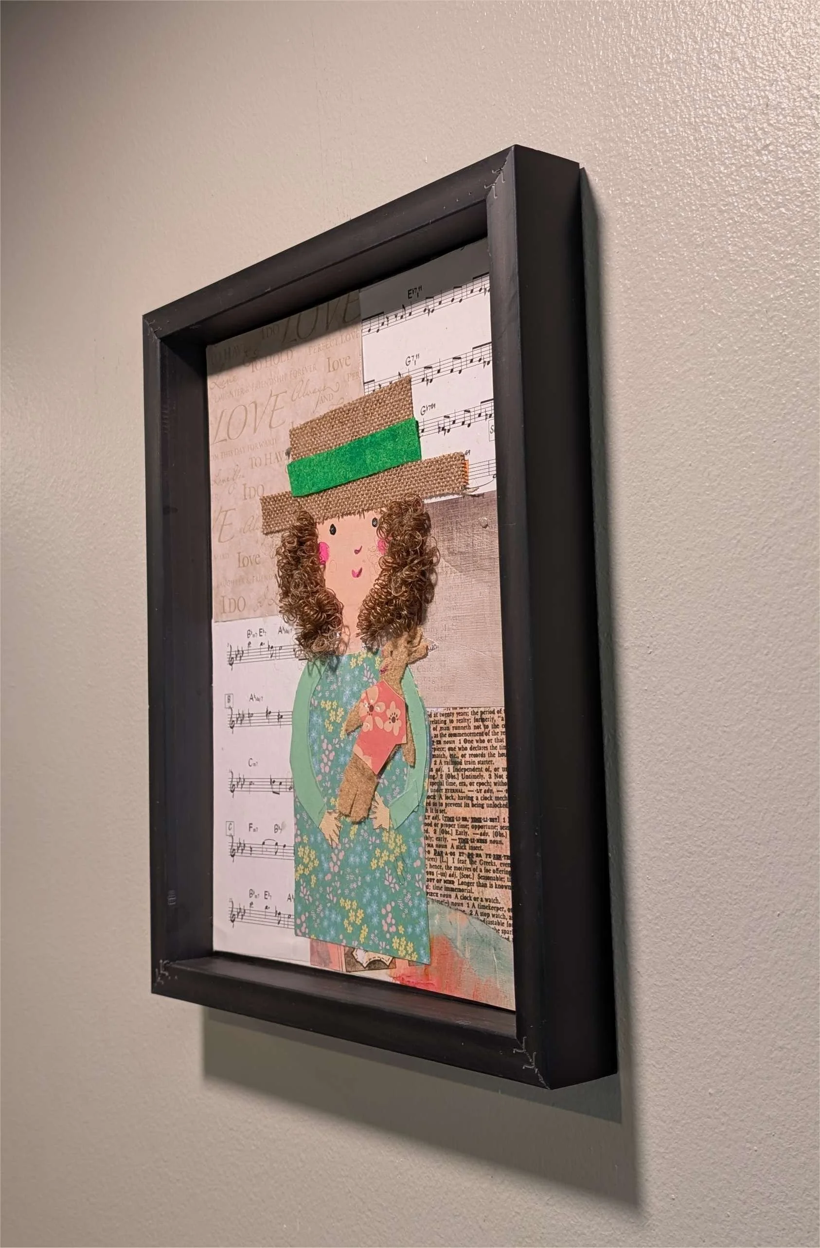 Textured mixed-media collage depicting a young girl with curly hair, with a hat on, holding her stuffed animal surrounded by sheet music-right-wall, by Sarasota Artist Debra Rich.