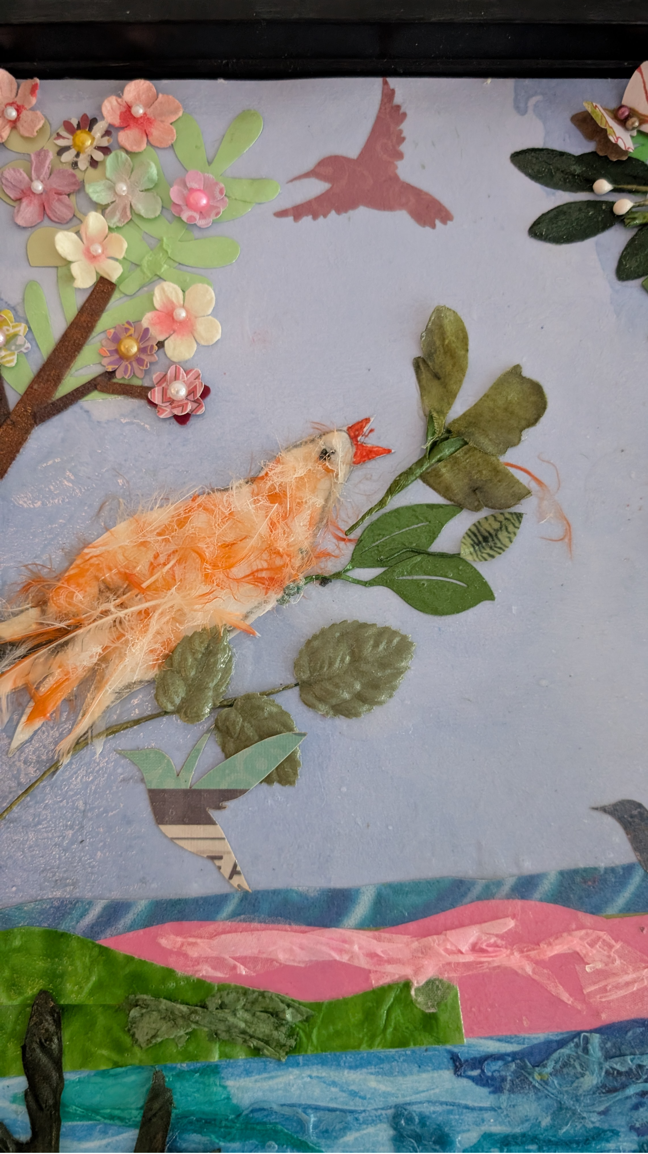 Close-up of left canary in Mango's Last Stand made from real feathers, with paper blossom tree and pink flower embellishments, by Debra Rich