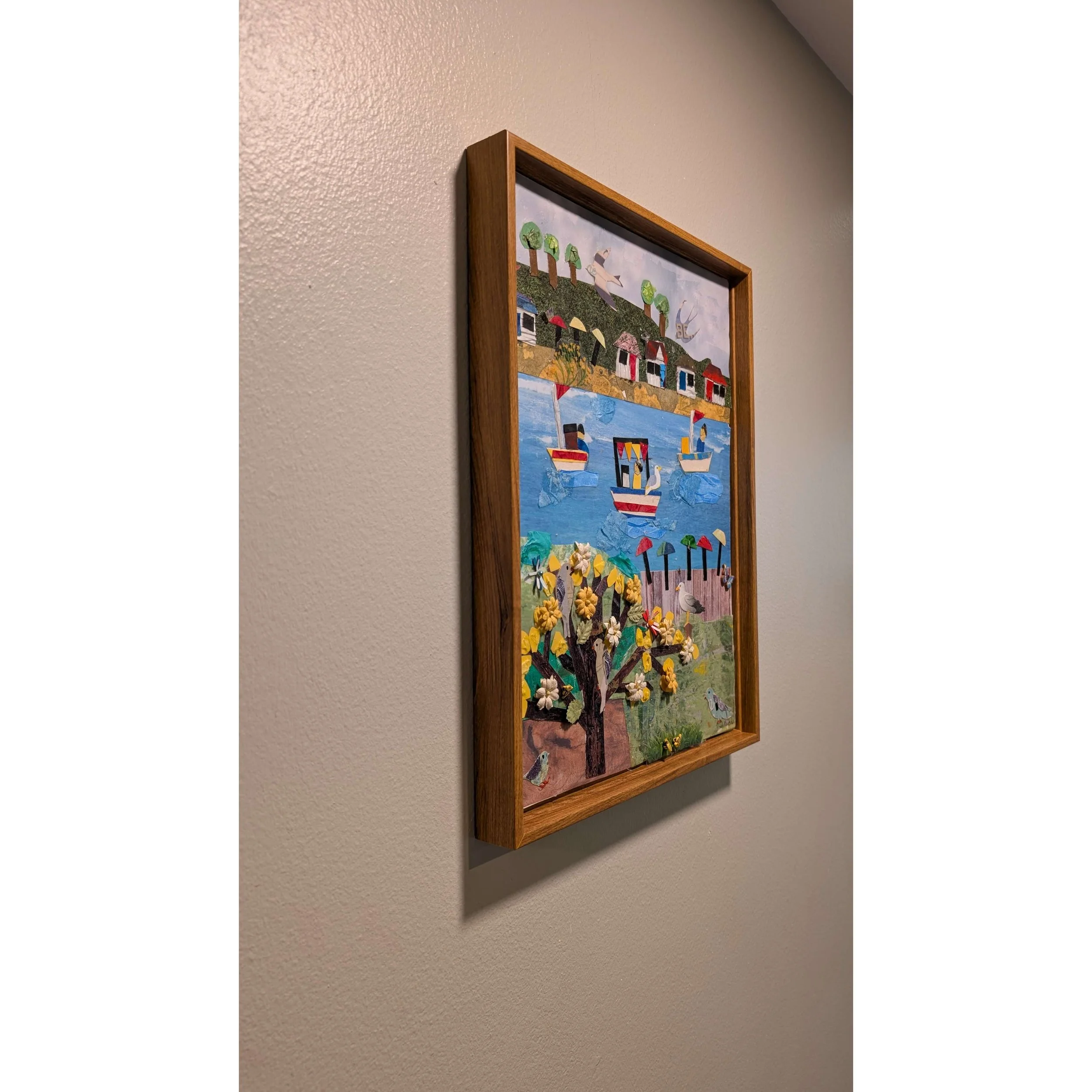 Side angle view of Sailing with Friends Collage Wall Art showing the thick wood frame and 3D textured layers.-left-side