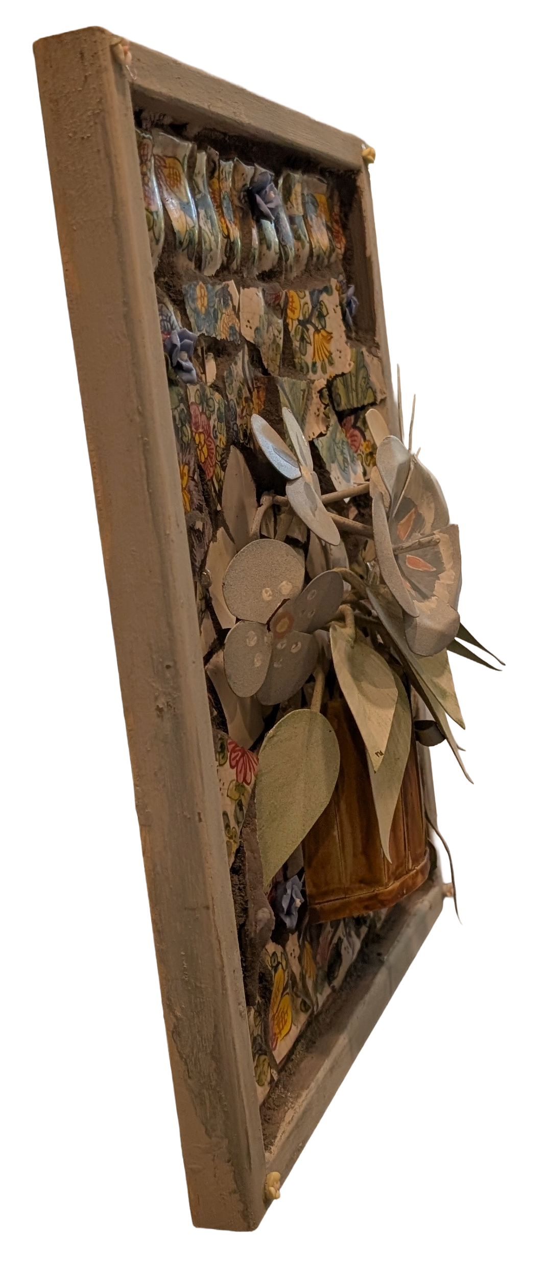 Blooming metal flowers in a pot with flowered mosaics and small flowers as an assemblage art -left side