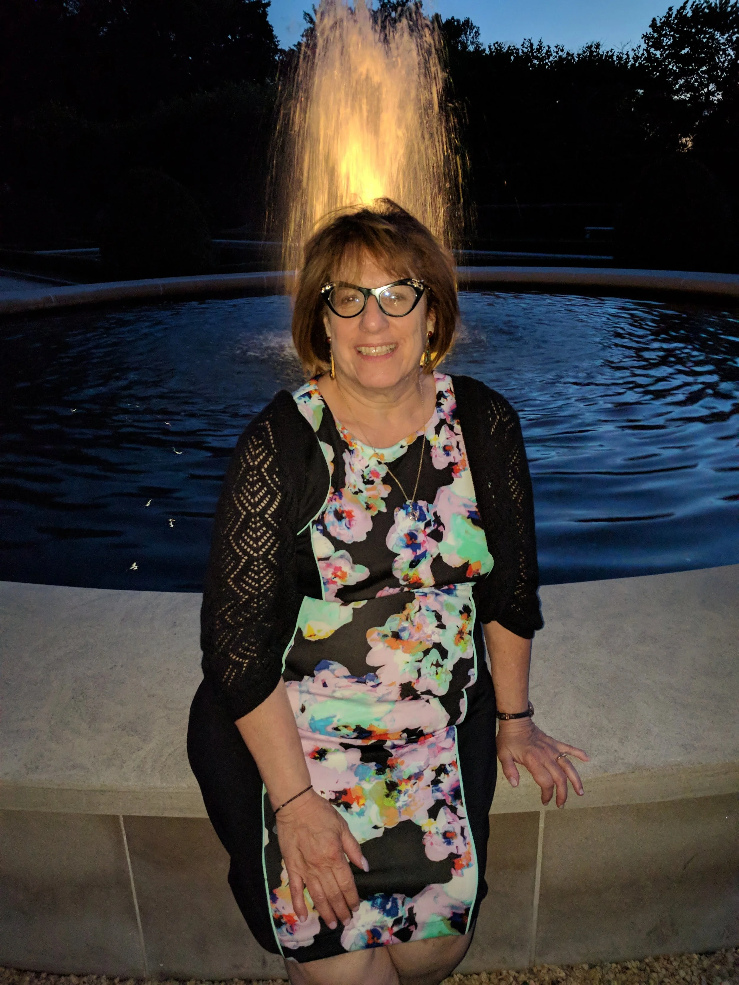 Debbie Rich, Sarasota mixed-media and mosaic artist, smiling outdoors by a fountain