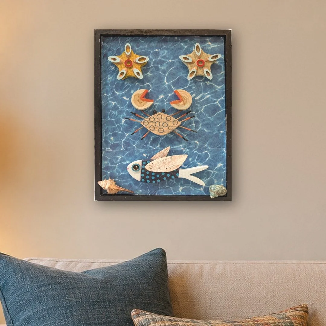 A Fish Tale assemblage hung above a beige sofa in a cozy living room-zoomed