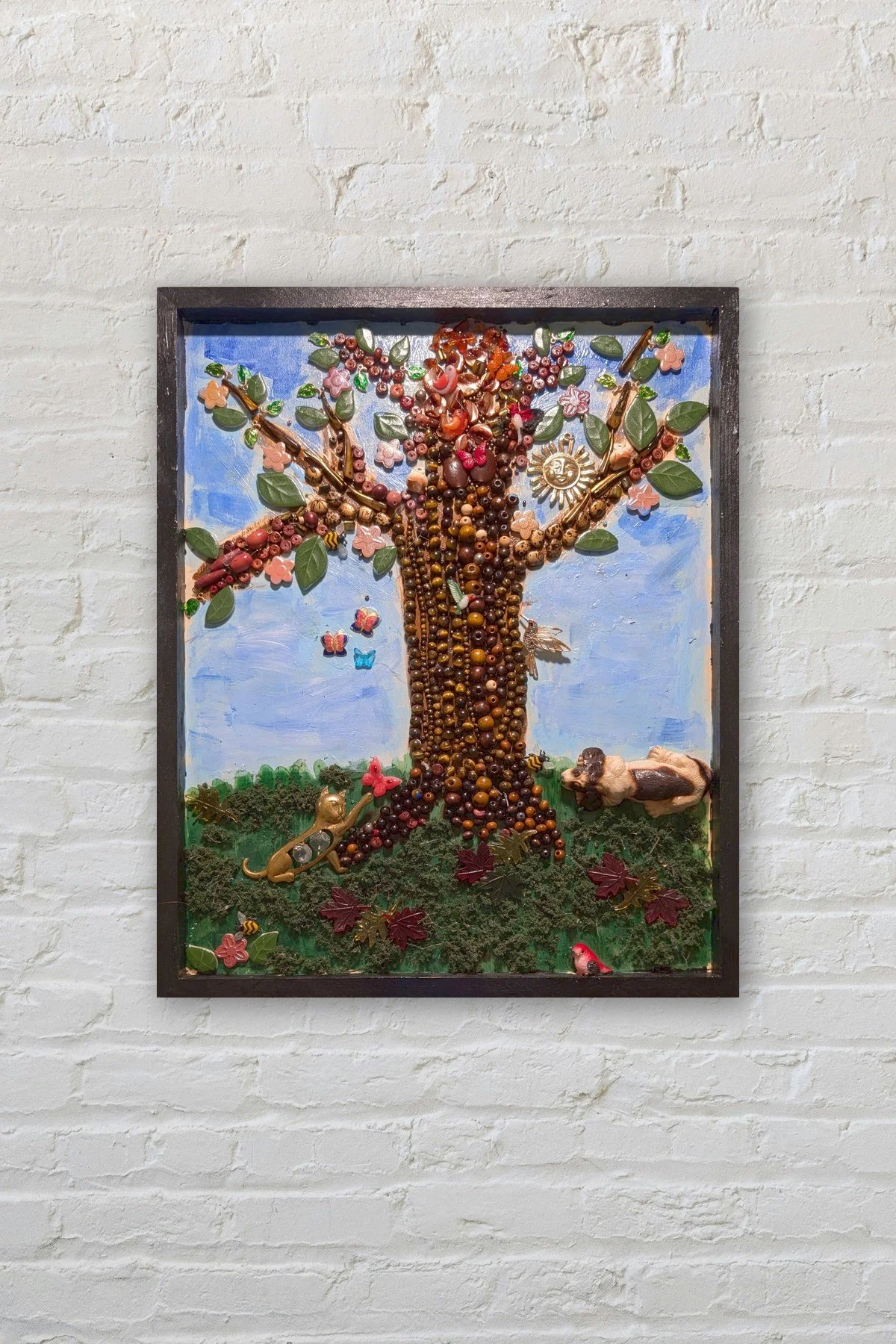 Last Tree costume jewelry tree assemblage on a white brick wall
