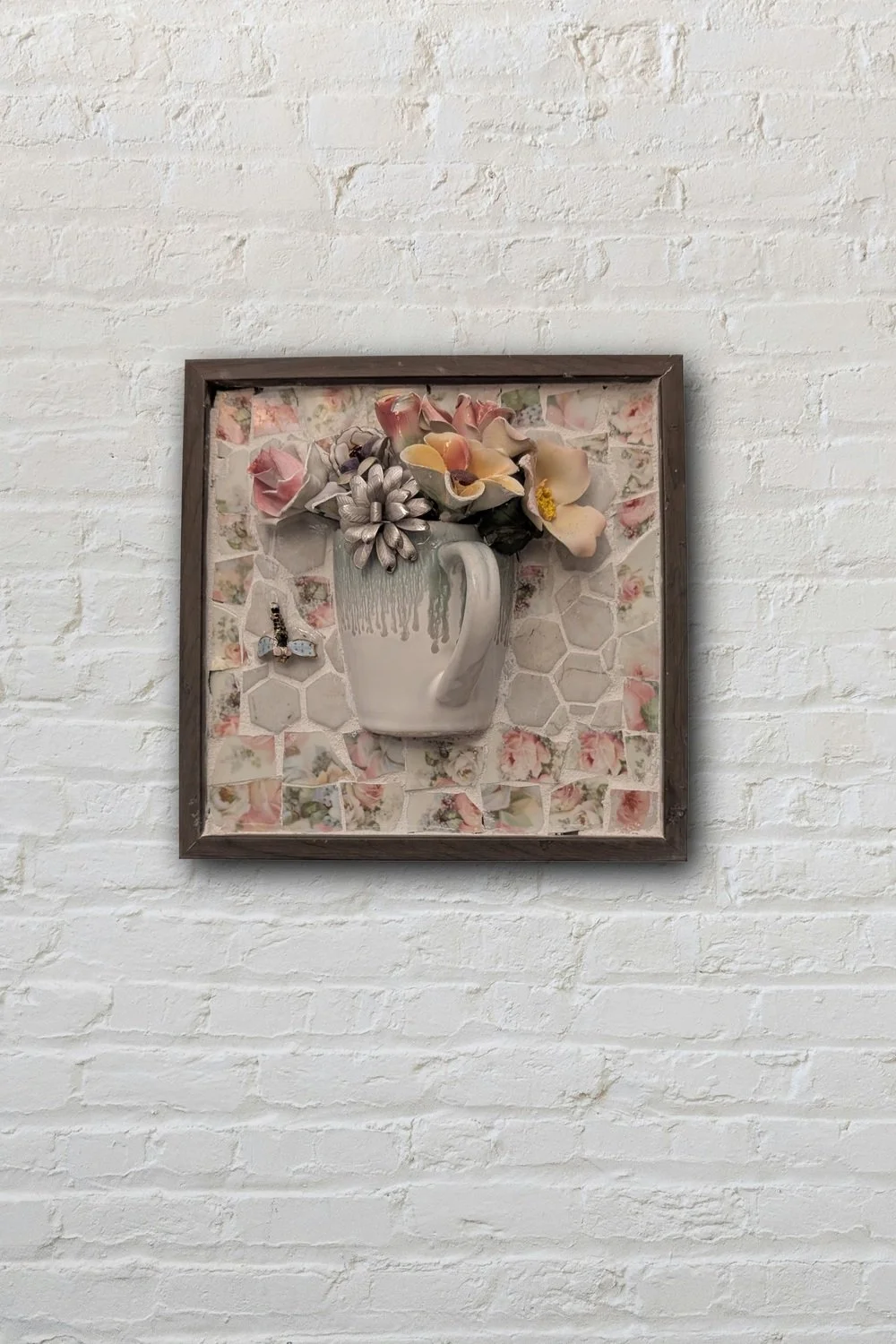Mug with flowers mosaic wall art on white brick — handcrafted ceramic and porcelain assemblage by Debra Rich, Sarasota FL