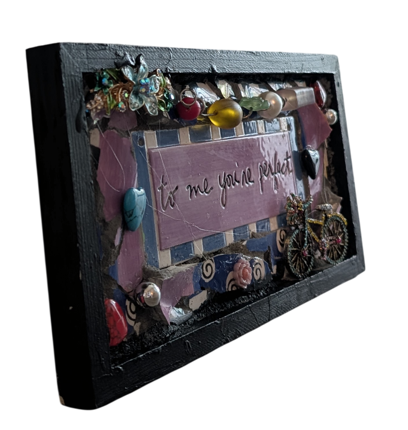 Left side view of To Me You're Perfect assemblage by Debra Rich showing frame depth and layered ceramic and jewelry elements