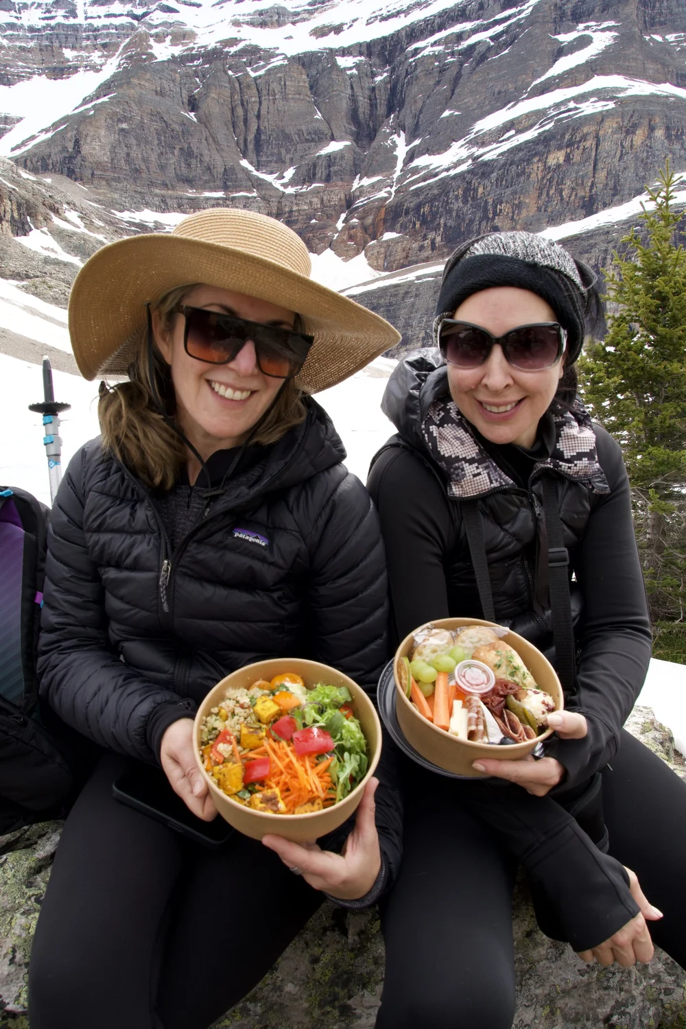 Two guests holding trail lunch bowls on a Columbia Wild Guides hike