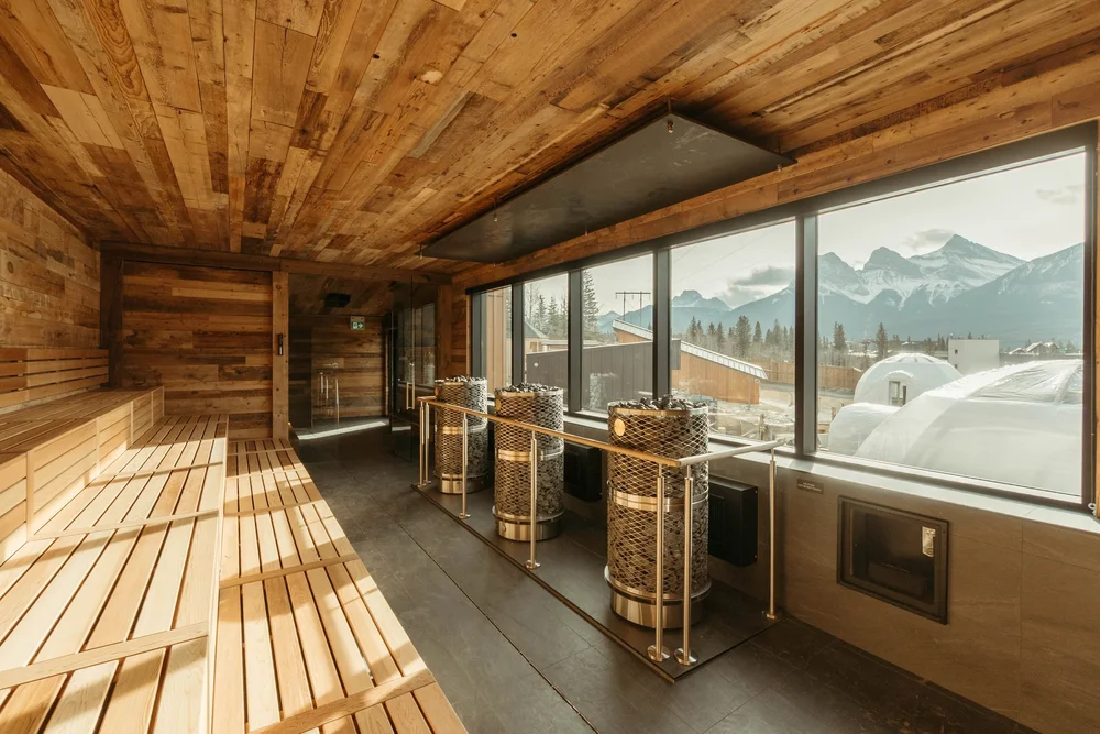 Wood-panelled sauna with large mountain-view windows at the Everwild Spa, Canmore