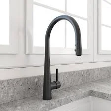 Black kitchen faucet over a granite countertop near a window