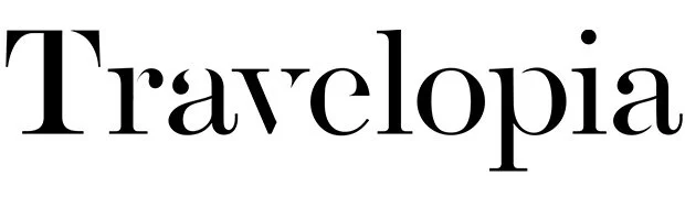 The word "Travelopia" written in black serif font on a white background.
