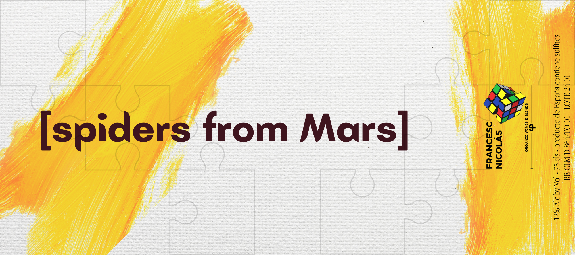 Etiqueta de producto con fondos amarillos y naranjas, y un cubo de rompecabezas Rubik en la esquina inferior derecha, que indica que es un producto orgánico de España con 12% de alcohol, sabor a vino y mezclas de frutas y nueces.