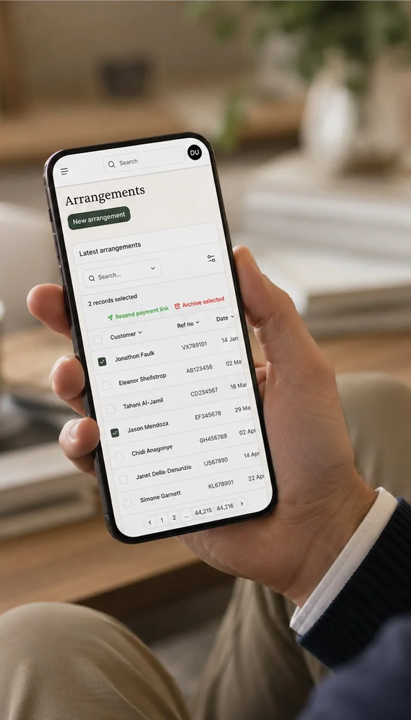 Man holding phone viewing ensemble payments tracking dashboard.jpg