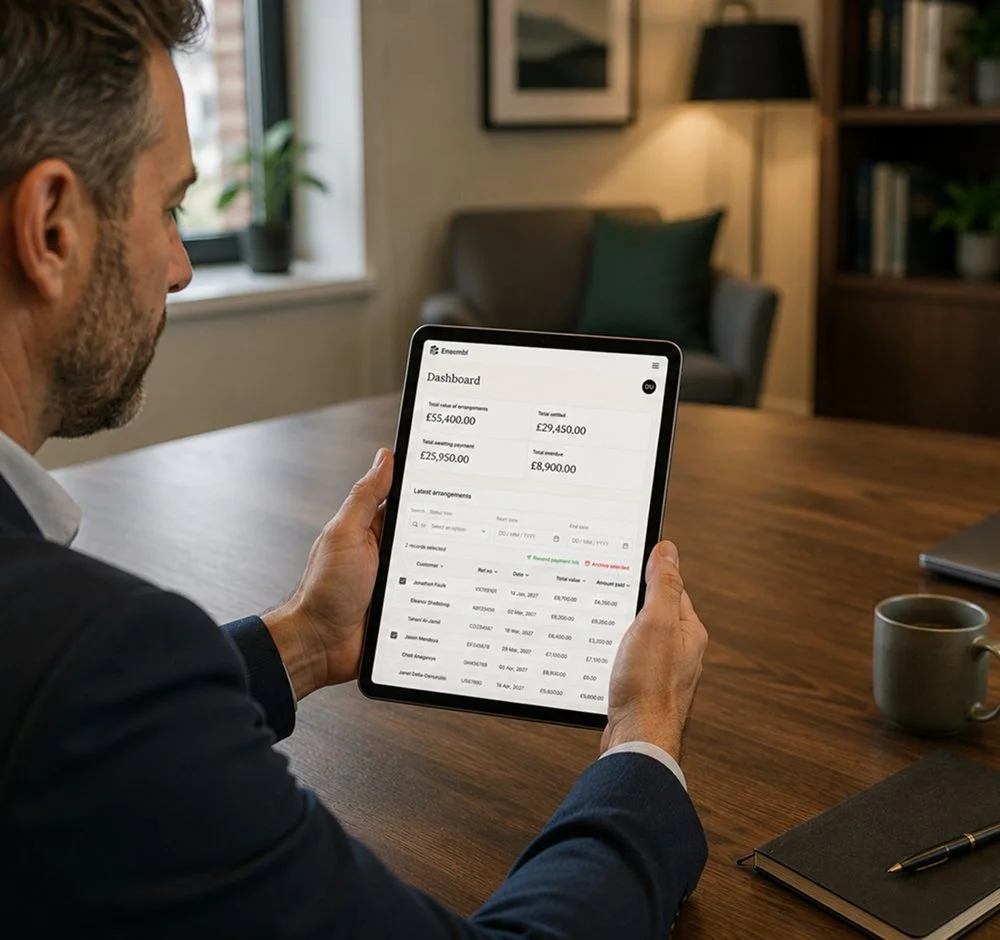 Man holding tablet looking at ensembl payments dashboard.jpg