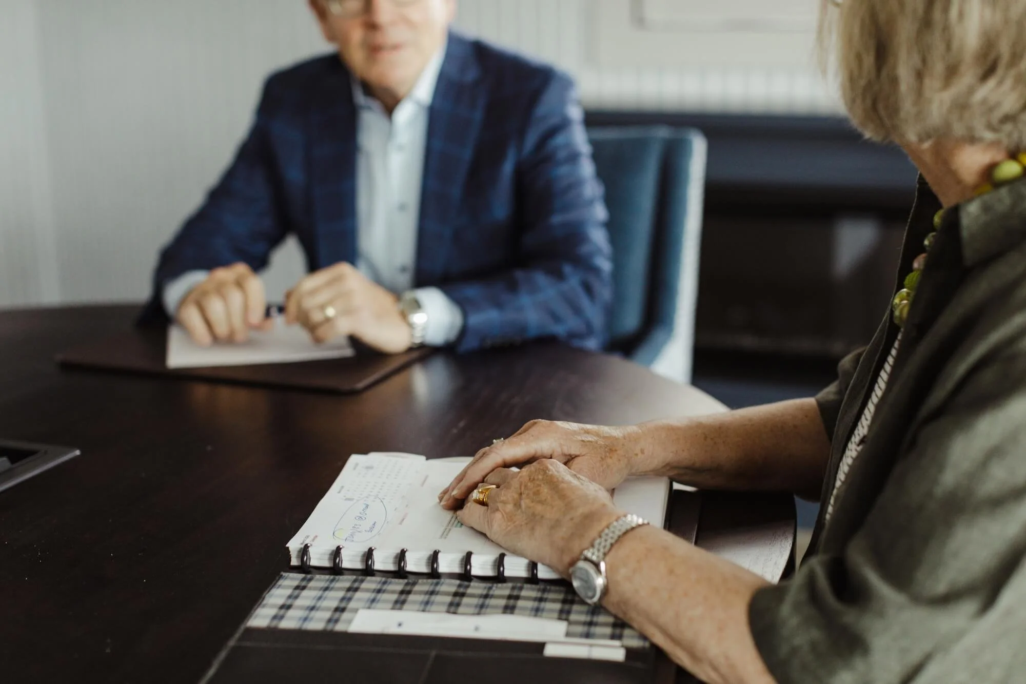 A client holds her portfolio in a meeting with Bill Boer at Grey Dunes.