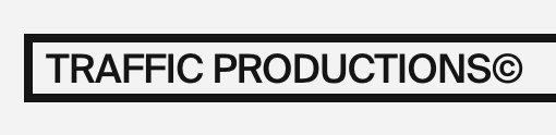 Sign that reads 'TRAFFIC PRODUCTIONS©' with black text on a white background, bordered by a black rectangle.