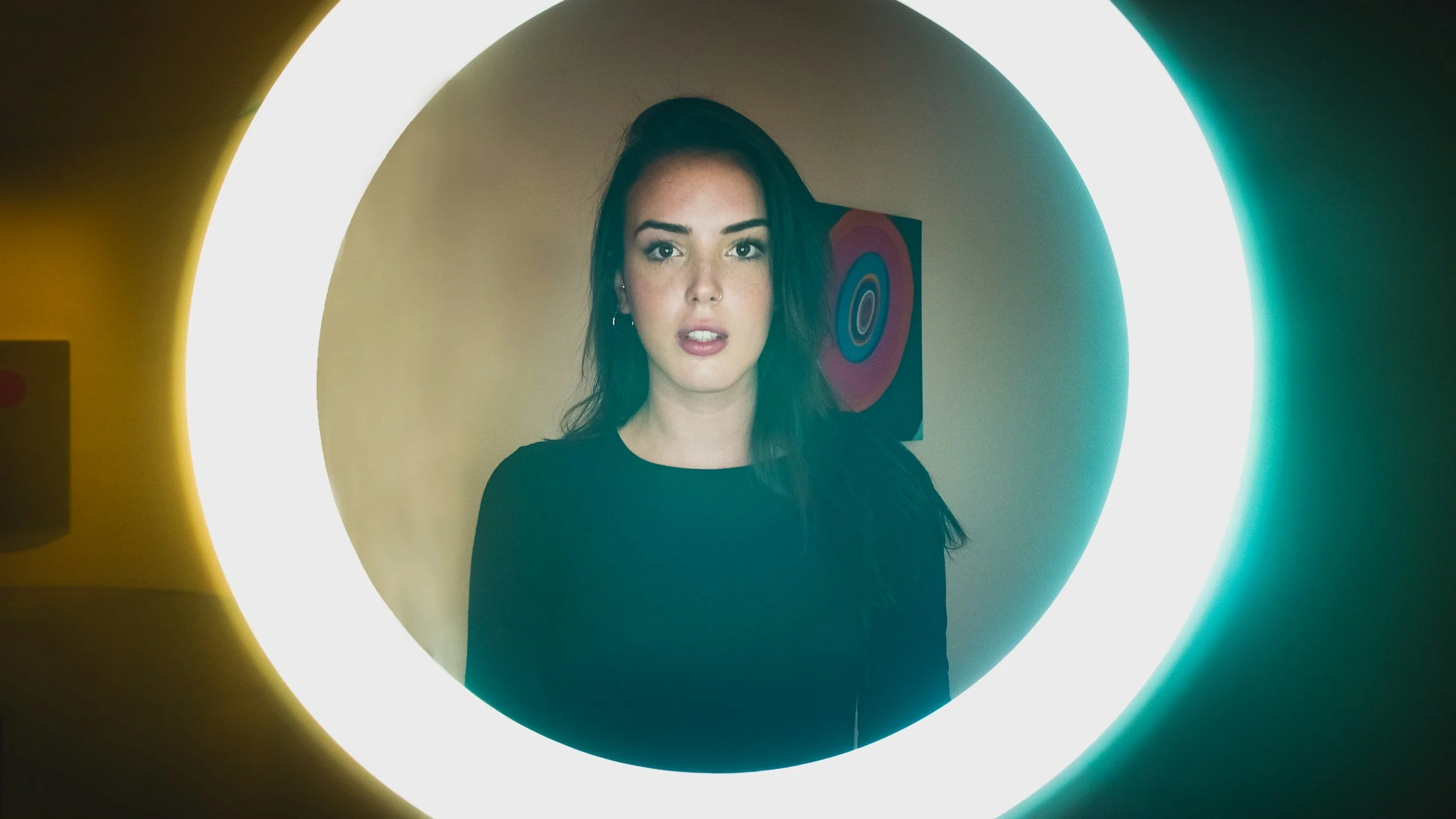 woman facing forward surrounded by exaggerated ring light