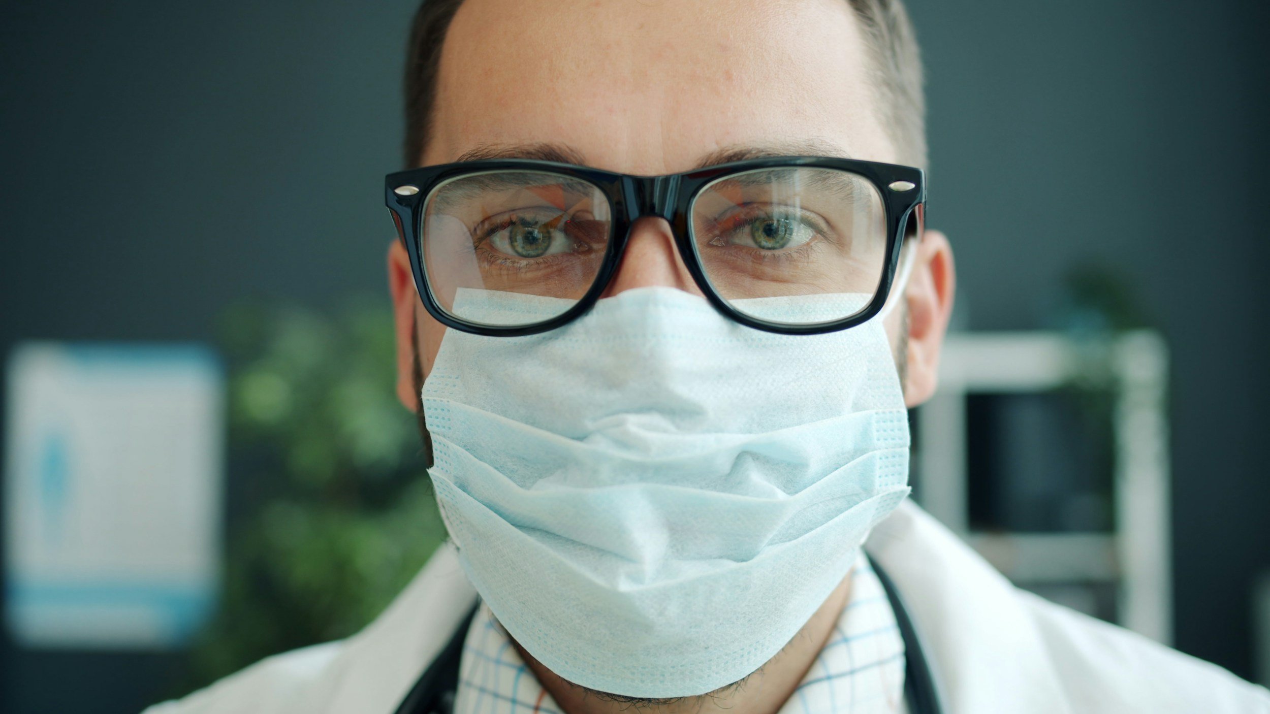 close up face shot of doctor wearing mask and glasses
