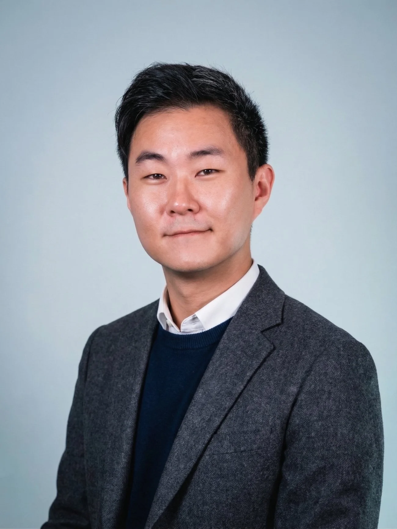 Korean American psychiatrist smiling in a blue blazer.