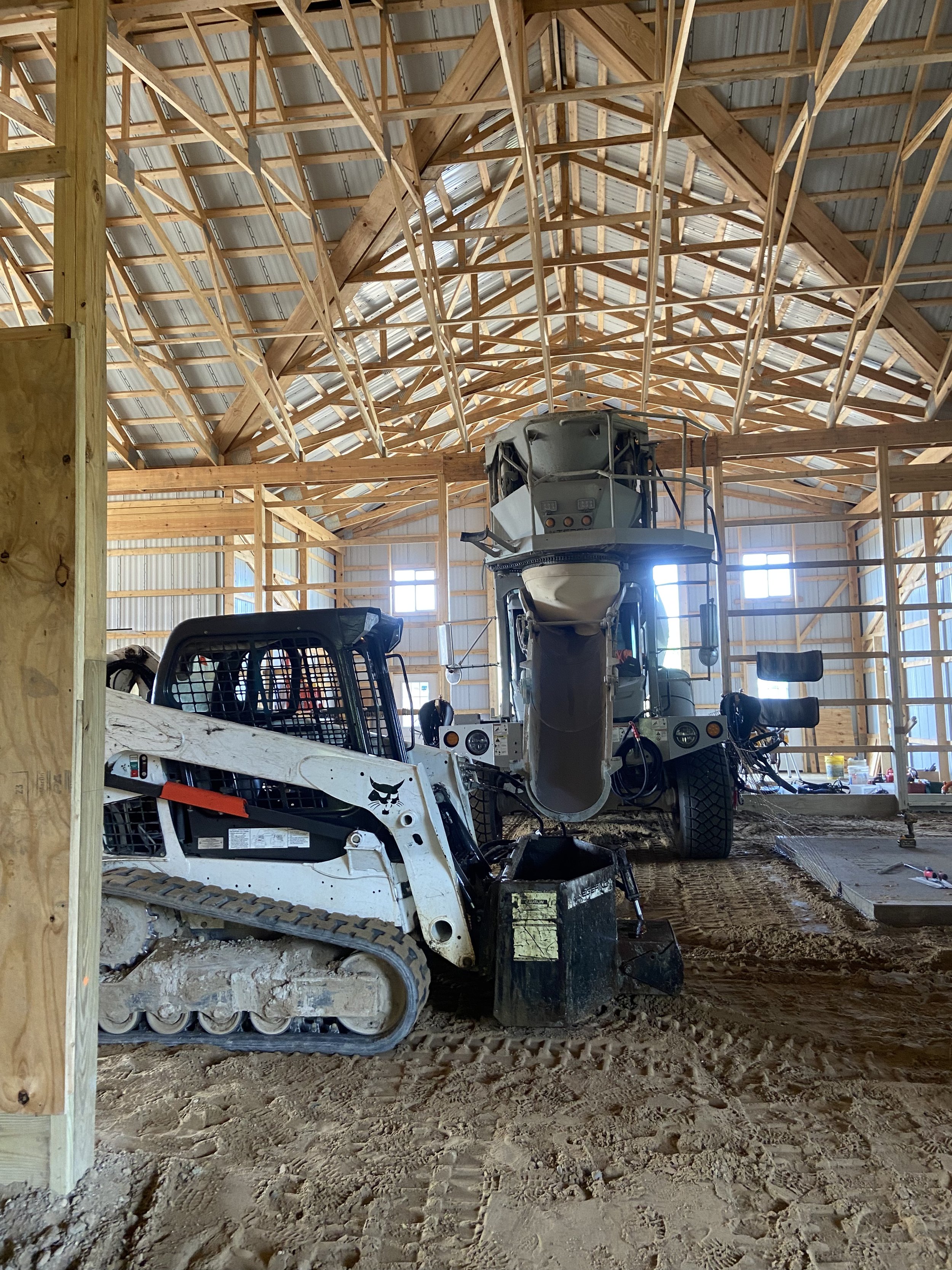 Bobcat with concrete bucket to pour concrete