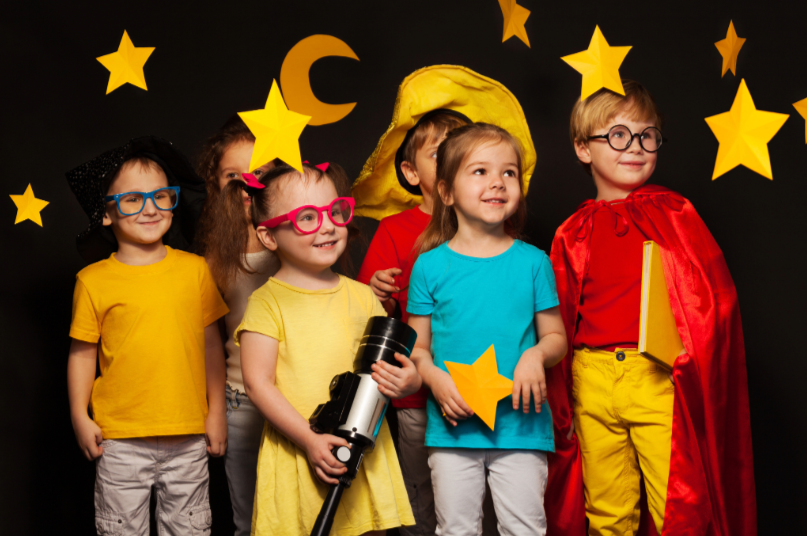 Children holding a telescope and star cutouts, exploring space and imagination through play.