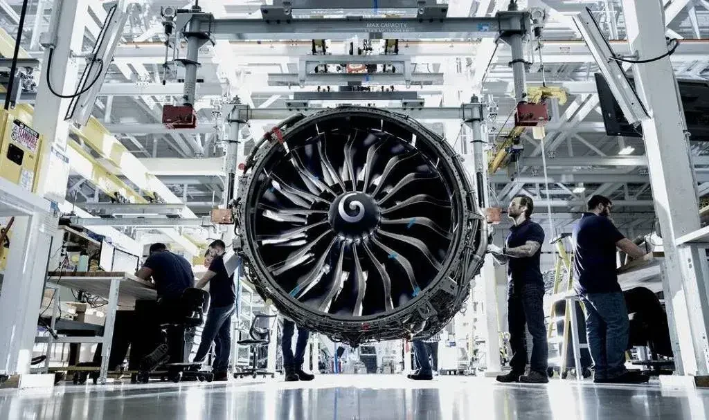 Engineers working on a turbine in an aerospace manufacturing warehouse