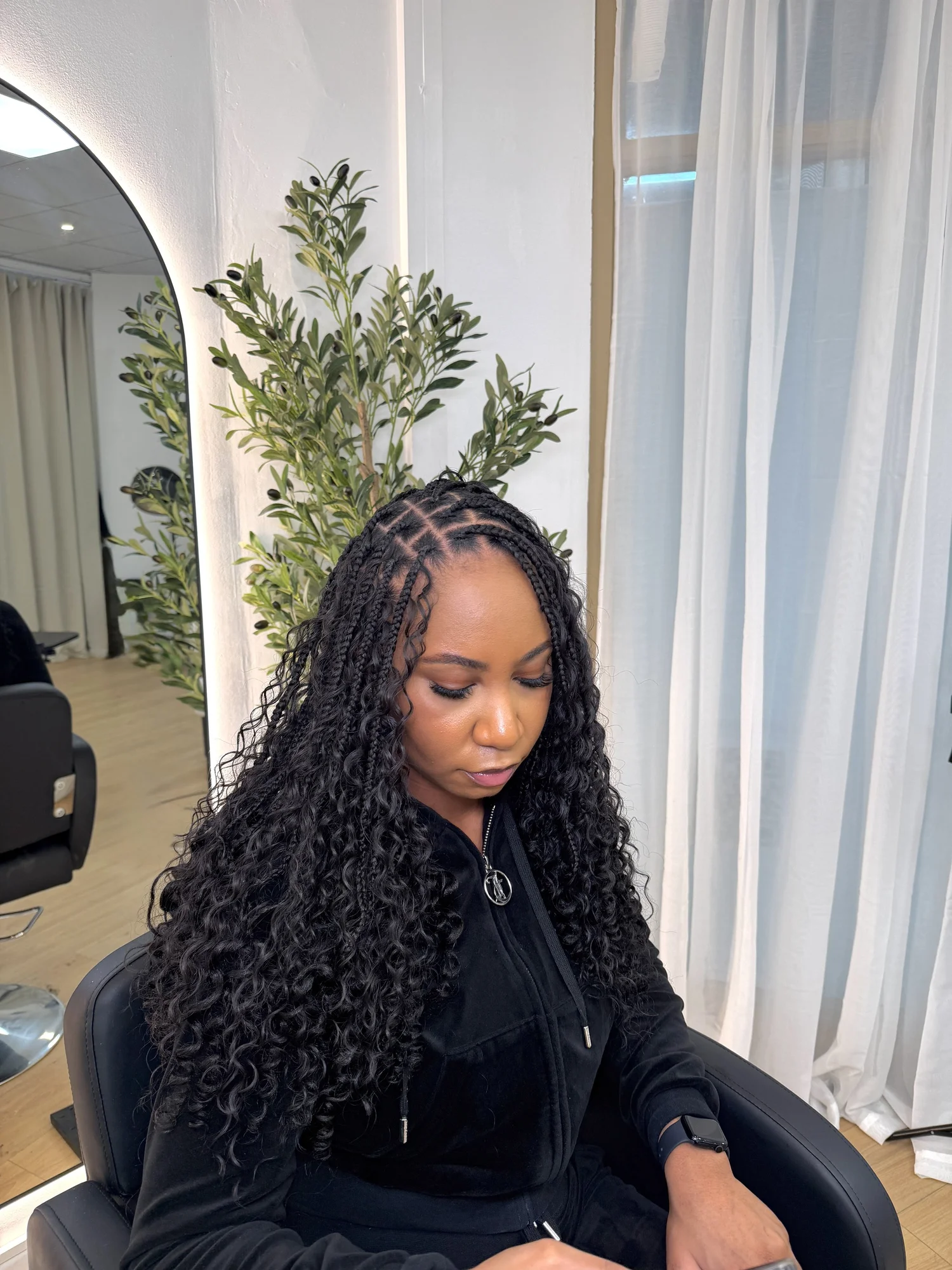 Client with long curly boho braids at AMIA Hair Studios in Grays, Essex