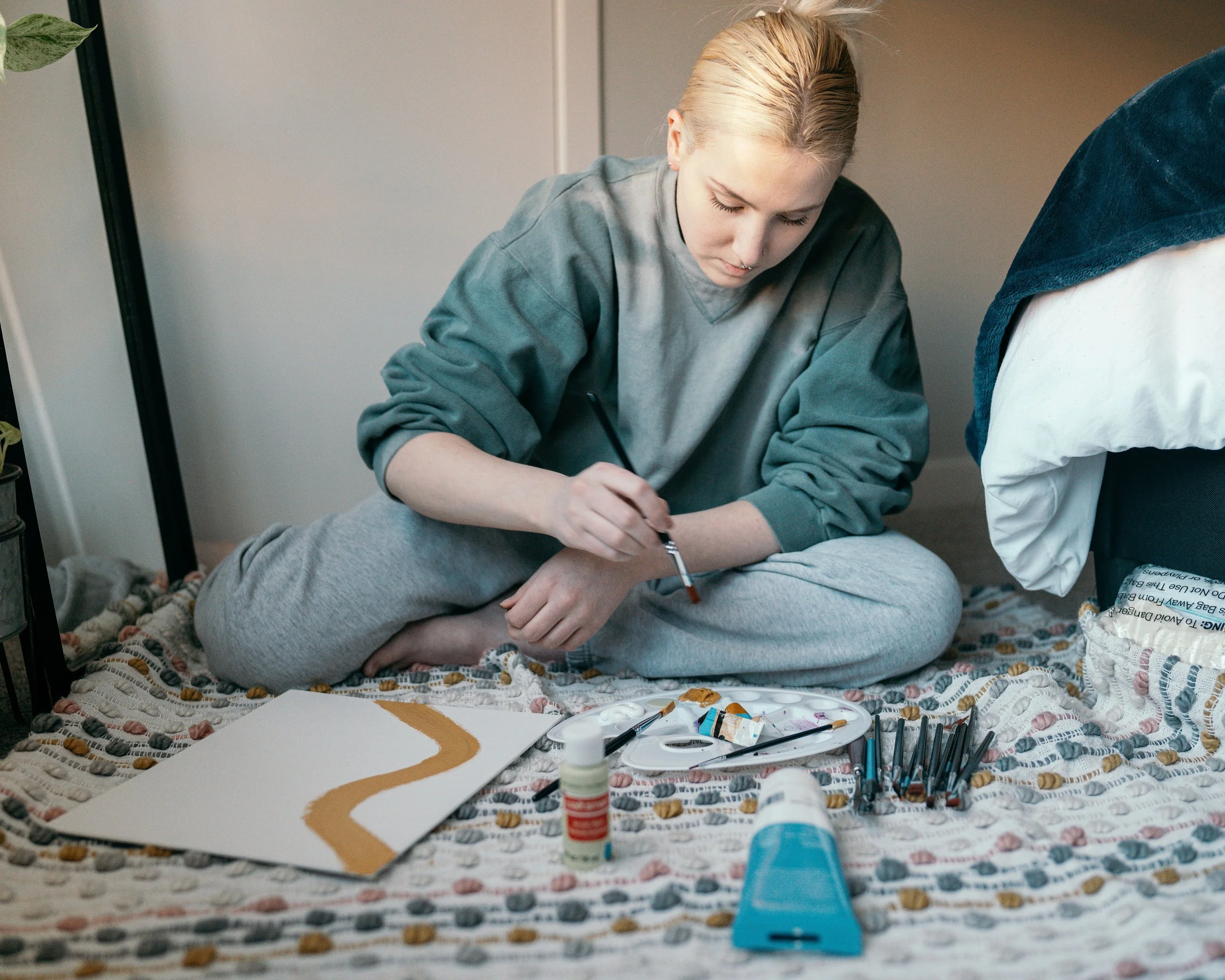 A disabled woman painting in her bedroom
