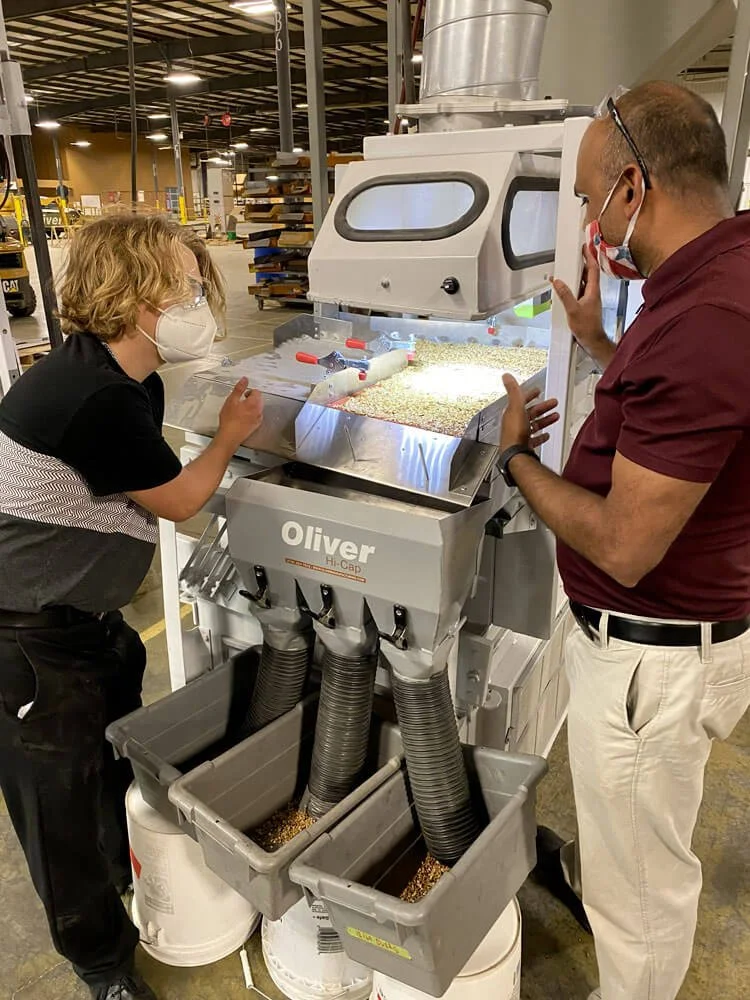 Oliver technician performing an on-site maintenance inspection at a grain processing facility.
