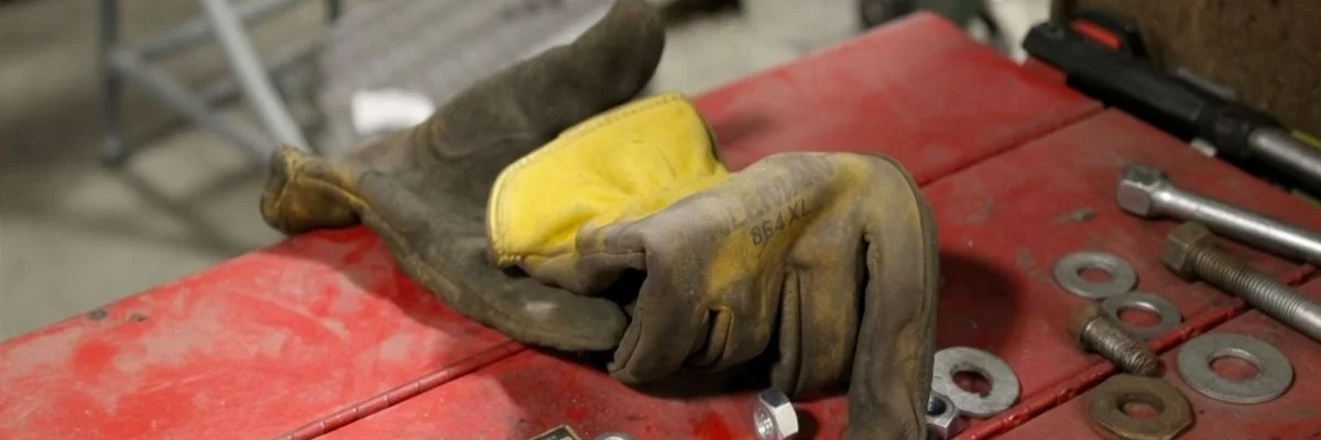Work gloves resting on processing equipment during machine service