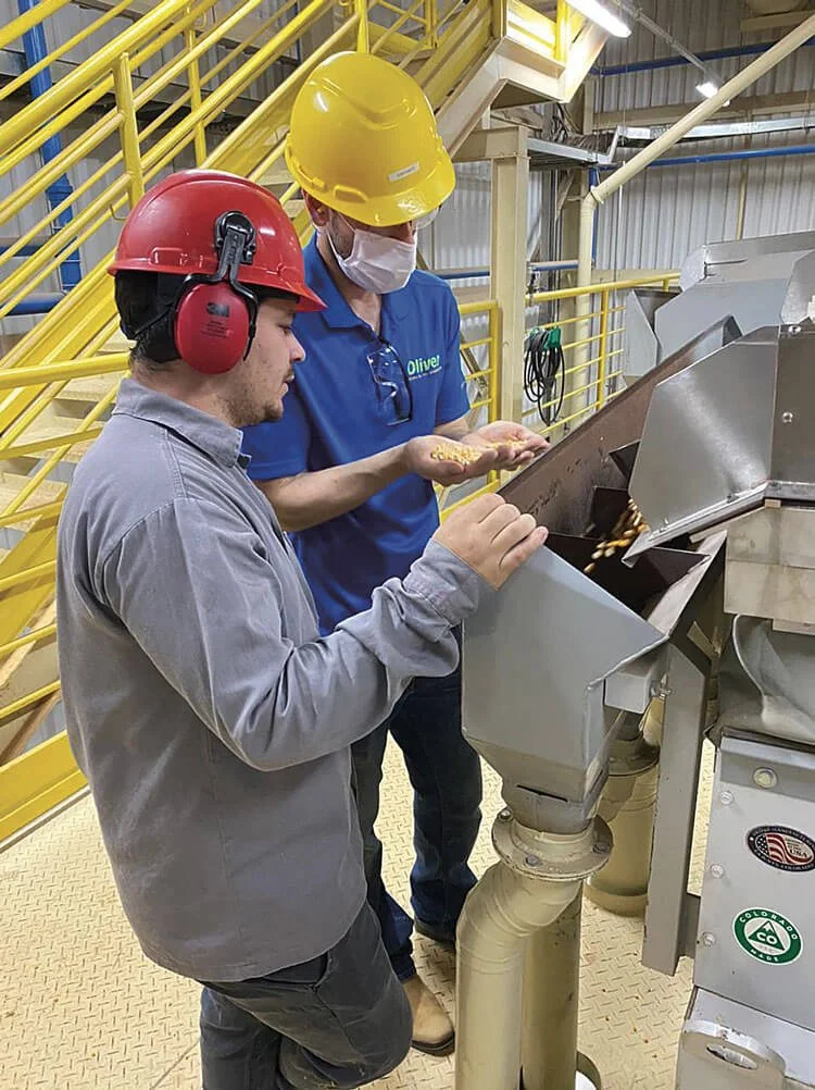 Oliver technician providing on-site equipment support and operator training at a processing facility.