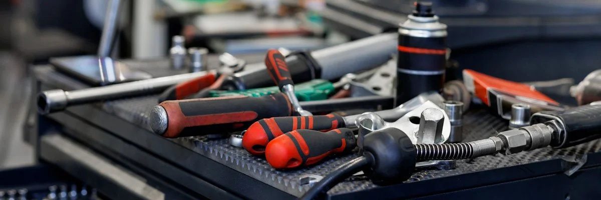Worn work gloves, bolts, and washers resting on red processing equipment
