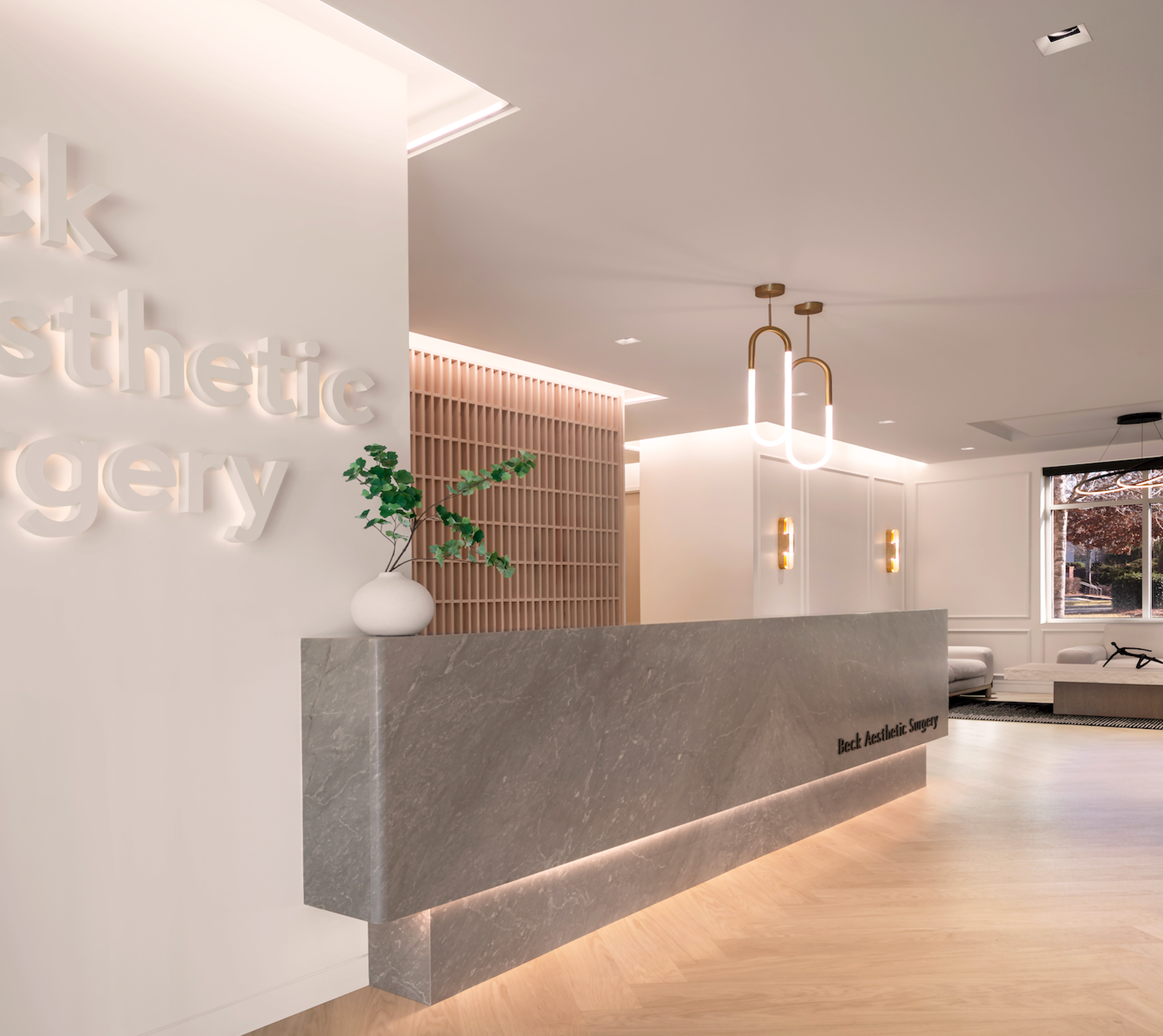 A hospitality inspired marble reception desk and geometric wooden accent wall.