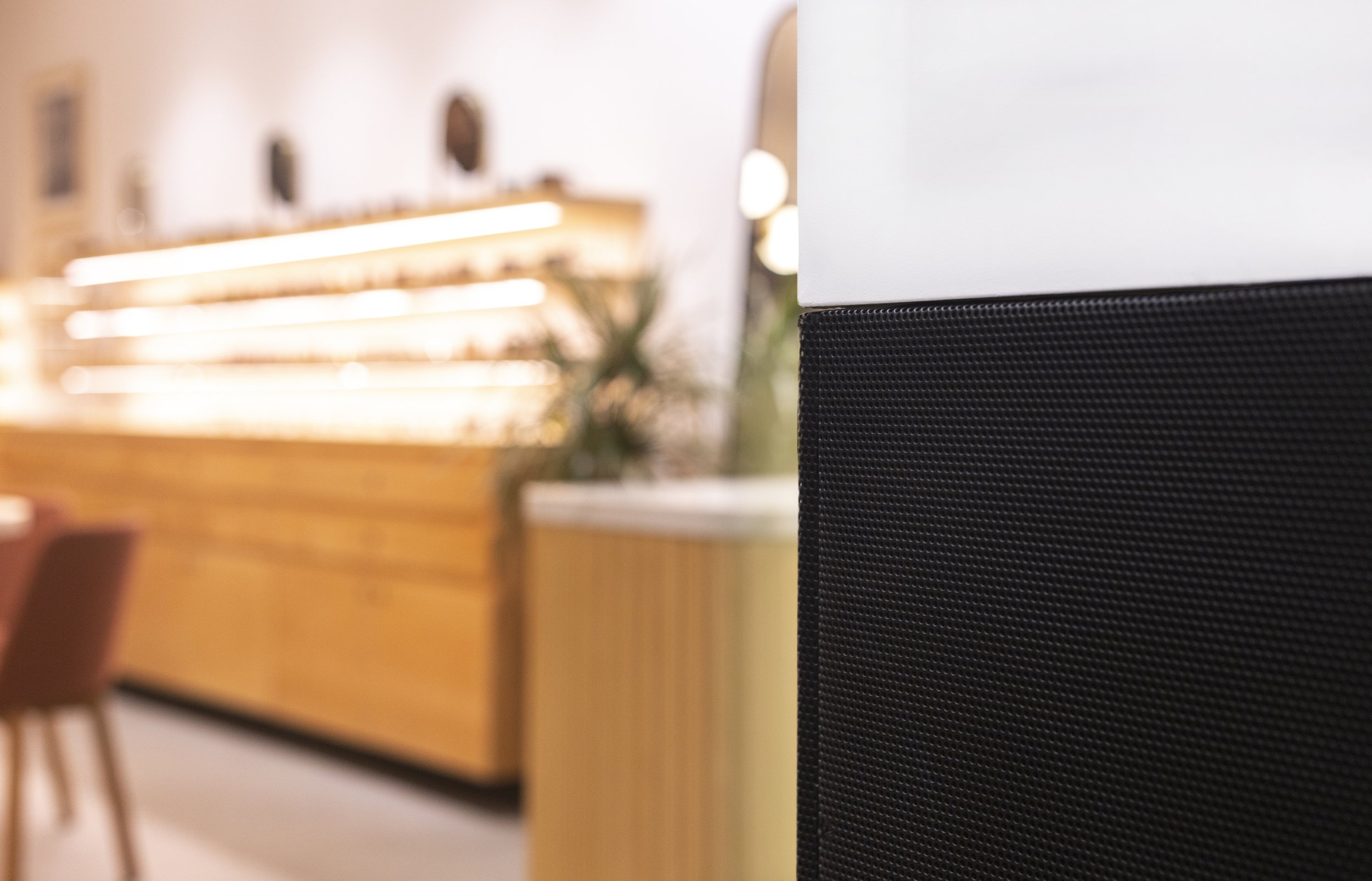 Textured black metal wainscotting with perforations.