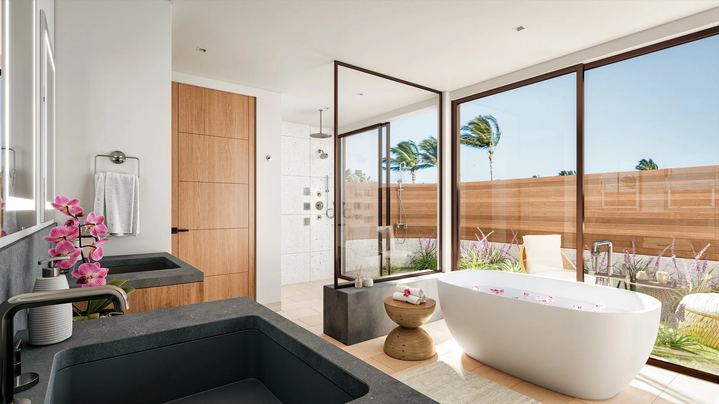 Modern bathroom with a large white freestanding bathtub outdoors, surrounded by flowers and a wooden privacy fence, with a glass shower enclosure, a wooden door, and a countertop with a sink and flowers, overlooking a blue sky and palm trees.