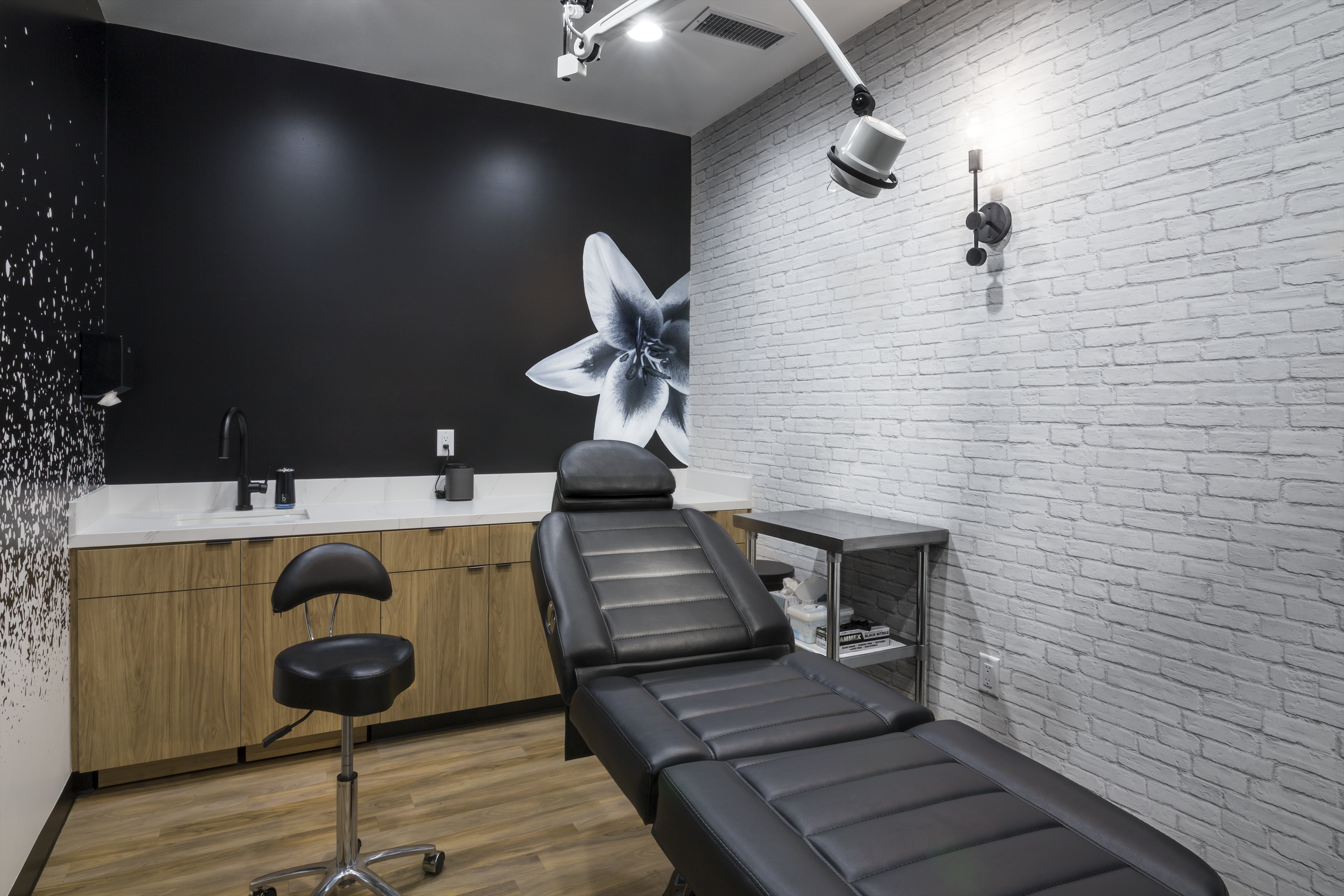 Medical grade wallpaper than looks like distressed white brick and graphic elements define the private treatment rooms.