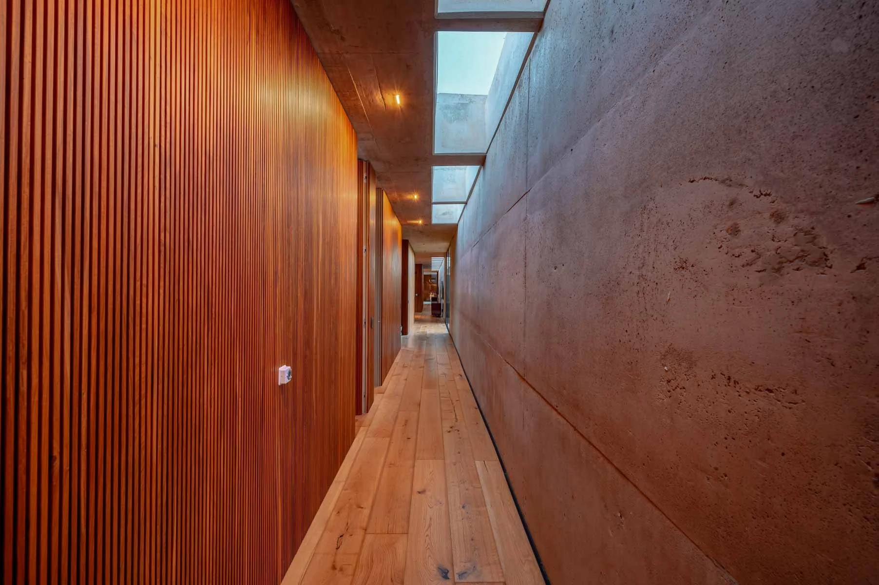 A wooden corridor with sky lights within a modern home design in South America
