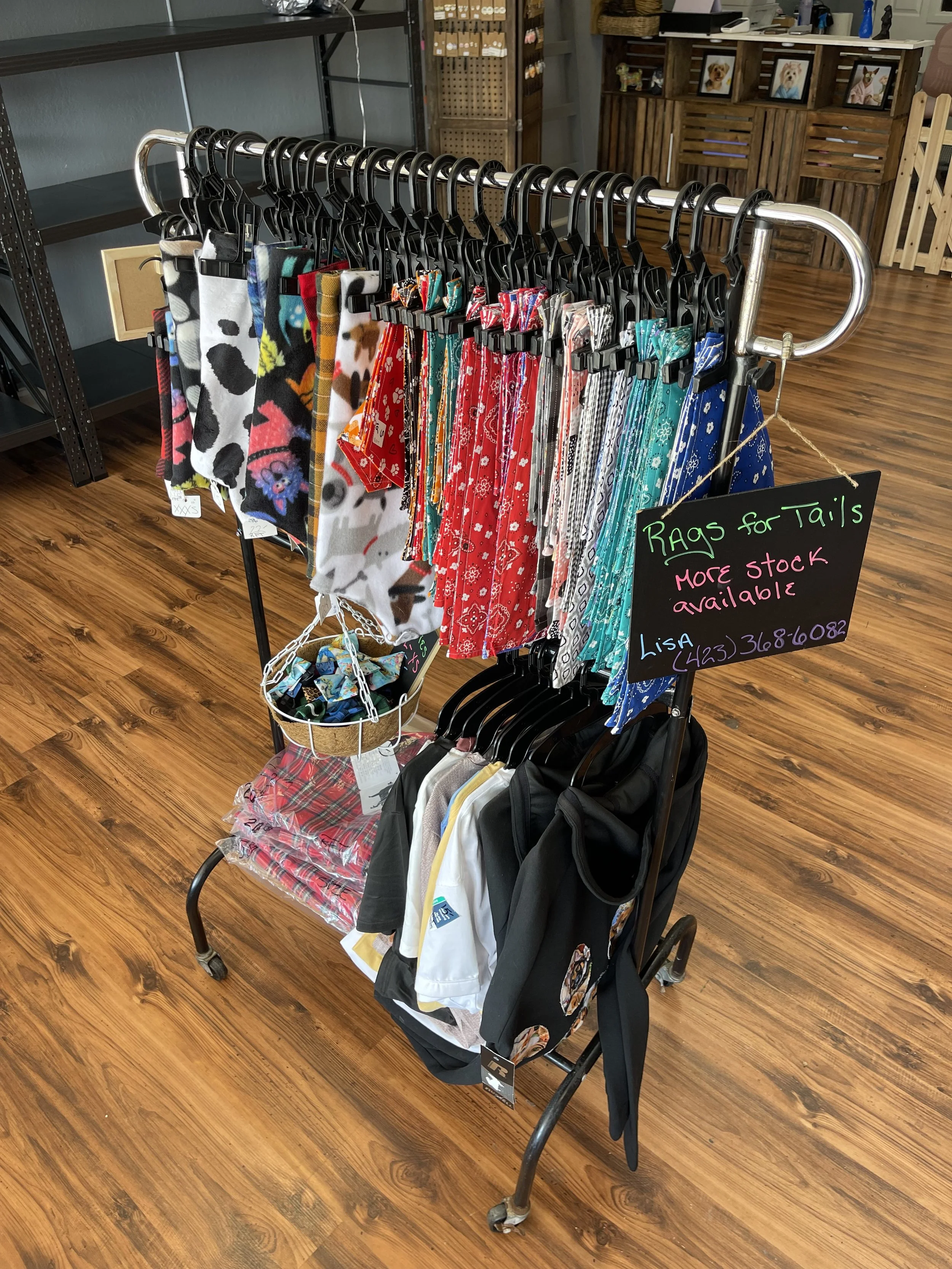 An image of a rack with pet bandanas and clothes hanging on it