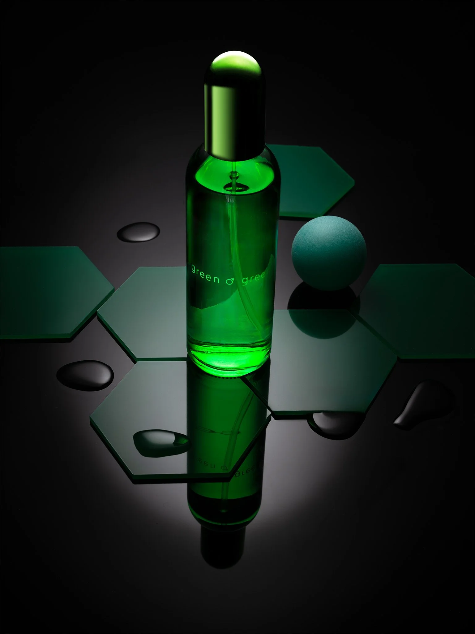 Professionelle Produktfotografie Colour Me Green Herrenparfüm, geometrische Inszenierung mit Hexagon-Elementen und Wassertropfen, grünes Key-Light, technischer Clean-Shot auf spiegelndem Grund.