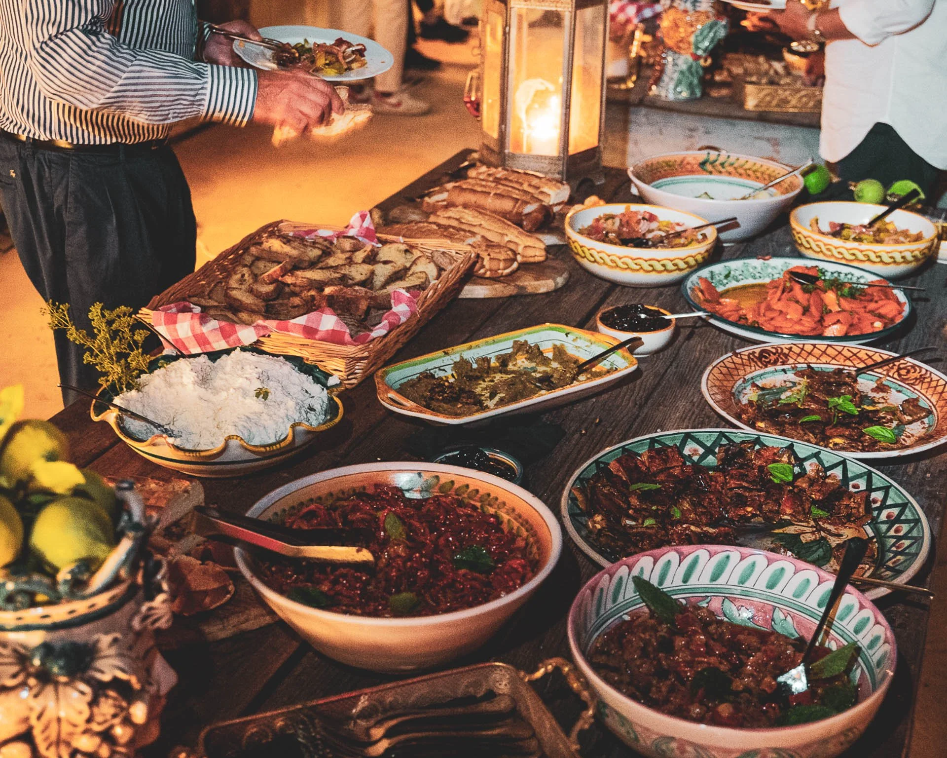 Lavagna di cibi tradizionali italiani con diverse pietanze, tra cui insalate, carni e pane, alimenti tipici di un buffet o di un pranzo in stile mediterraneo.
