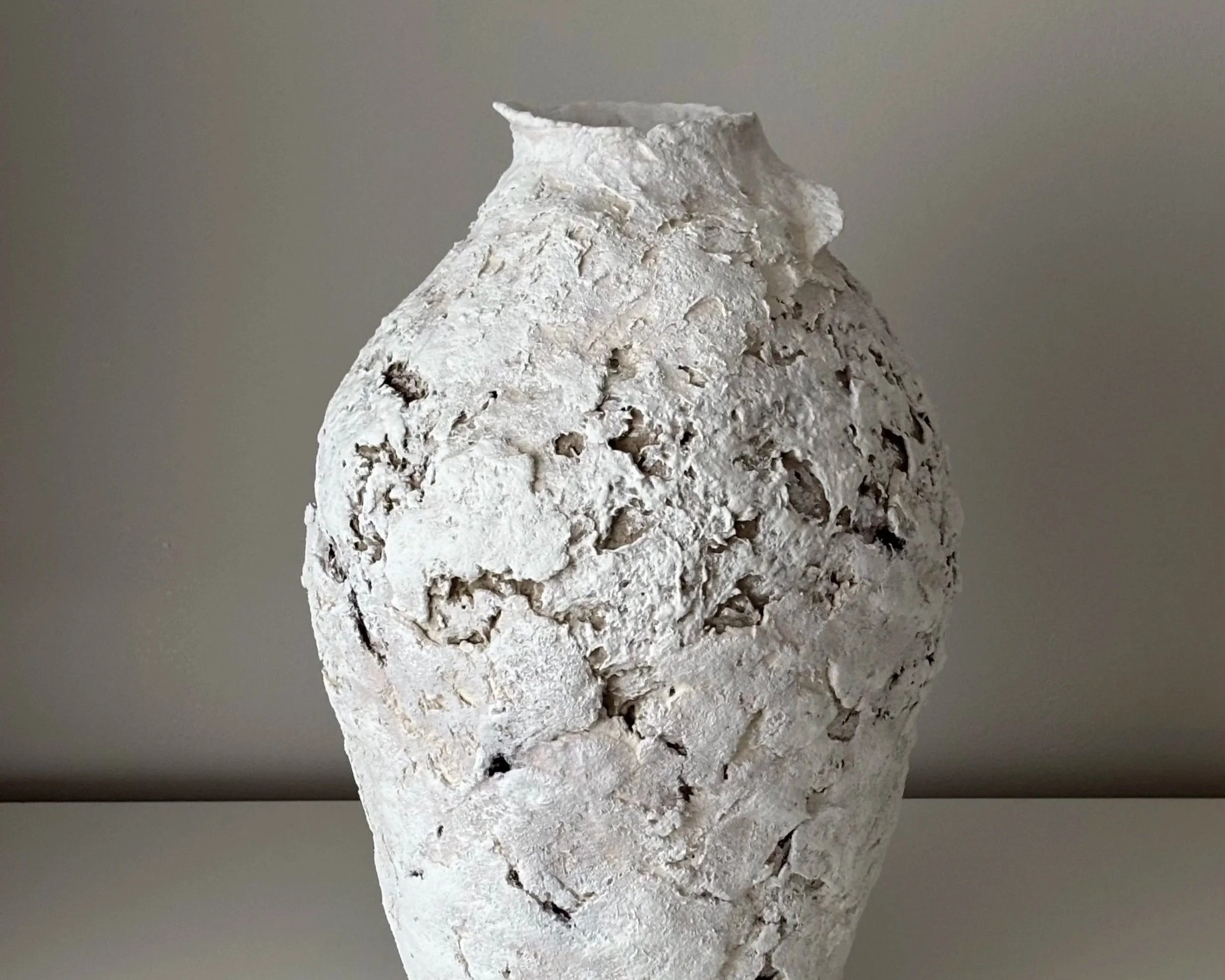 Textured Vessel N.22, off-white paper clay vessel viewed from an alternate angle highlighting asymmetrical shape, from Papier Atelier London
