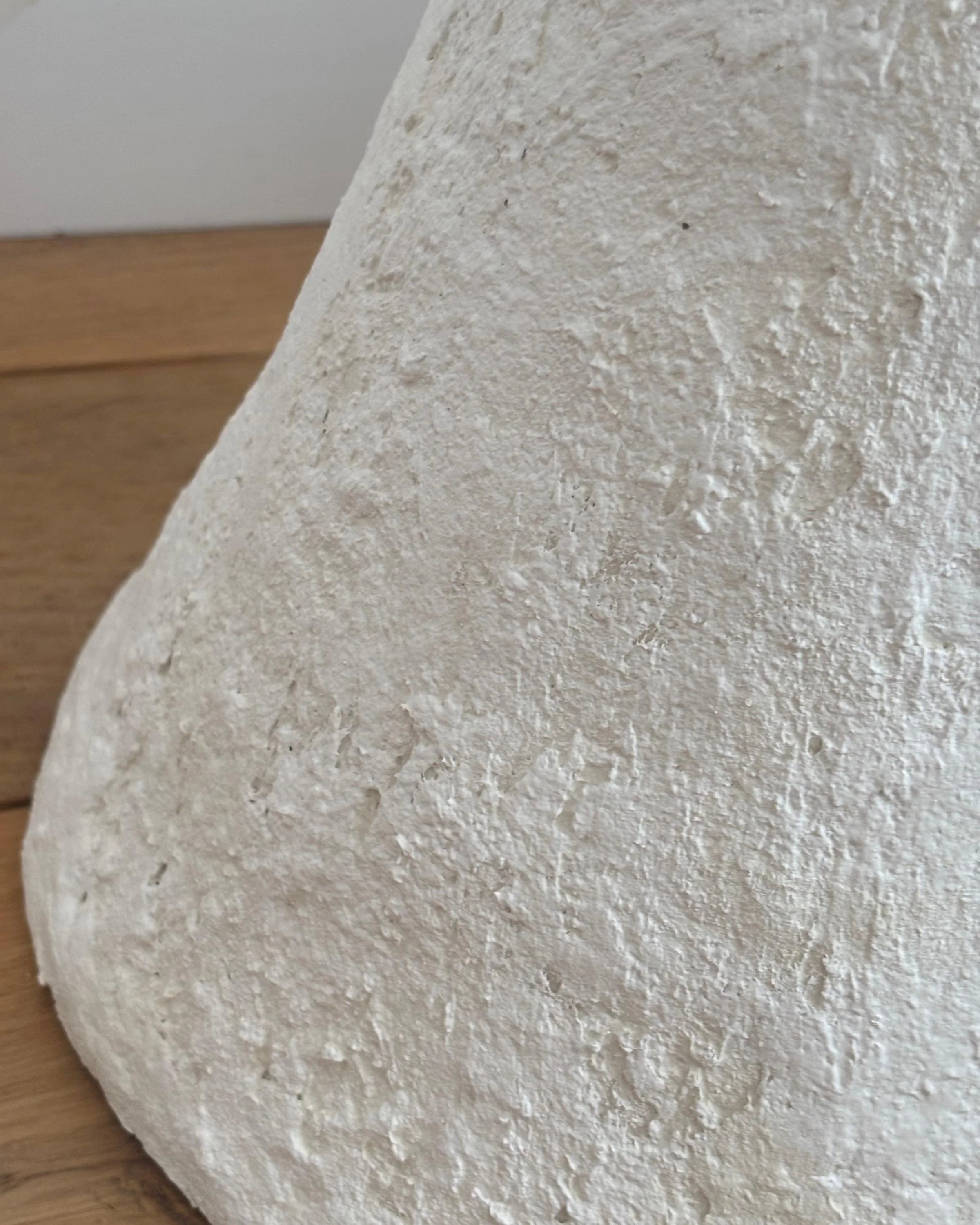 Side Table N.30, handmade white paper clay side table, disc top on a cone base, in a room setting. Papier Atelier London