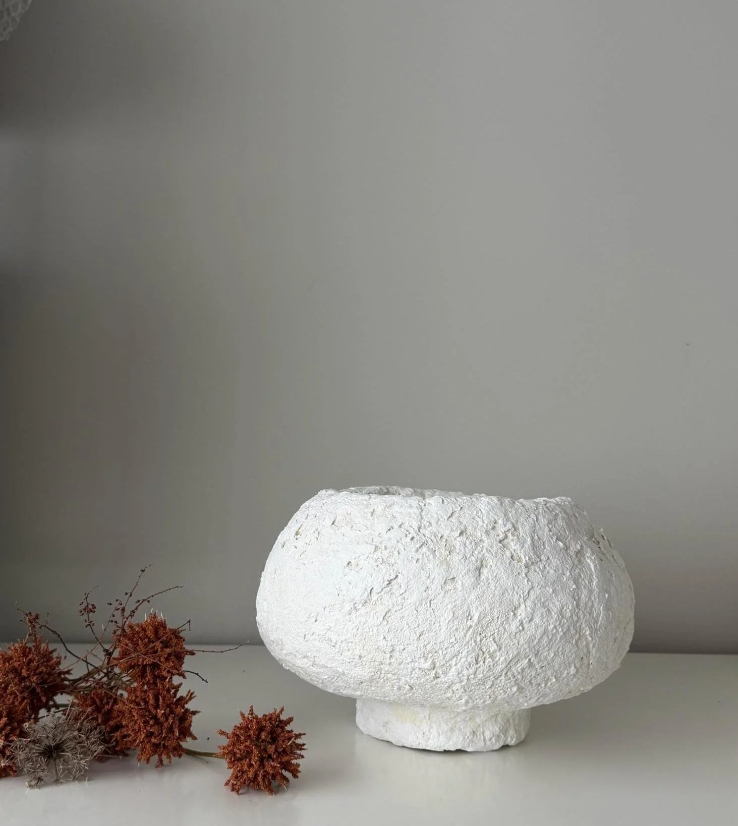 Footed Bowl N.27, handmade white paper clay bowl, on a low foot, in a room setting. Papier Atelier London