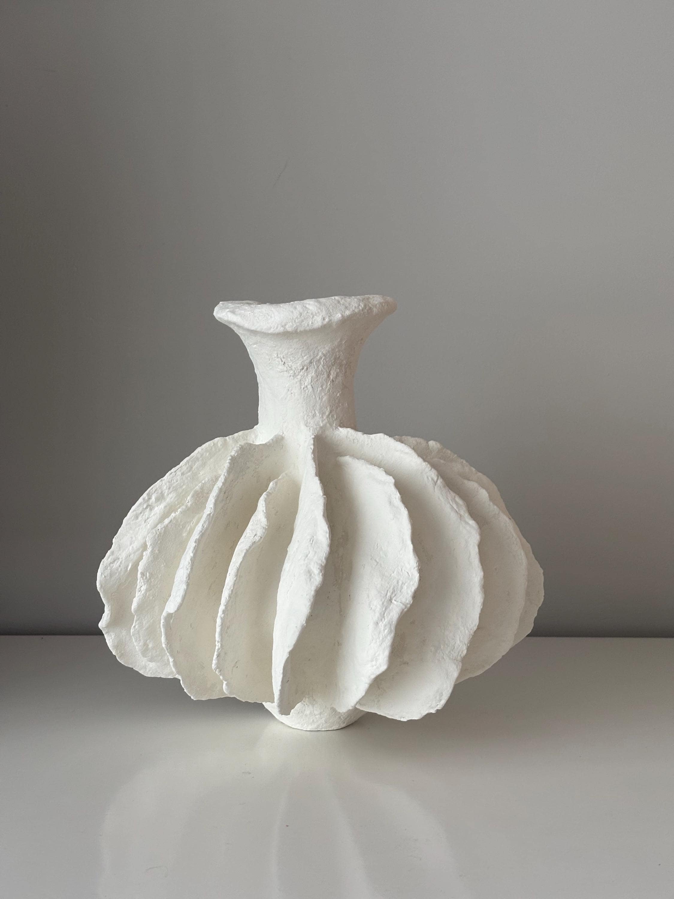 Pleated Vase N.28, handmade white pleated paper clay vase, folded form, front view. Papier Atelier London