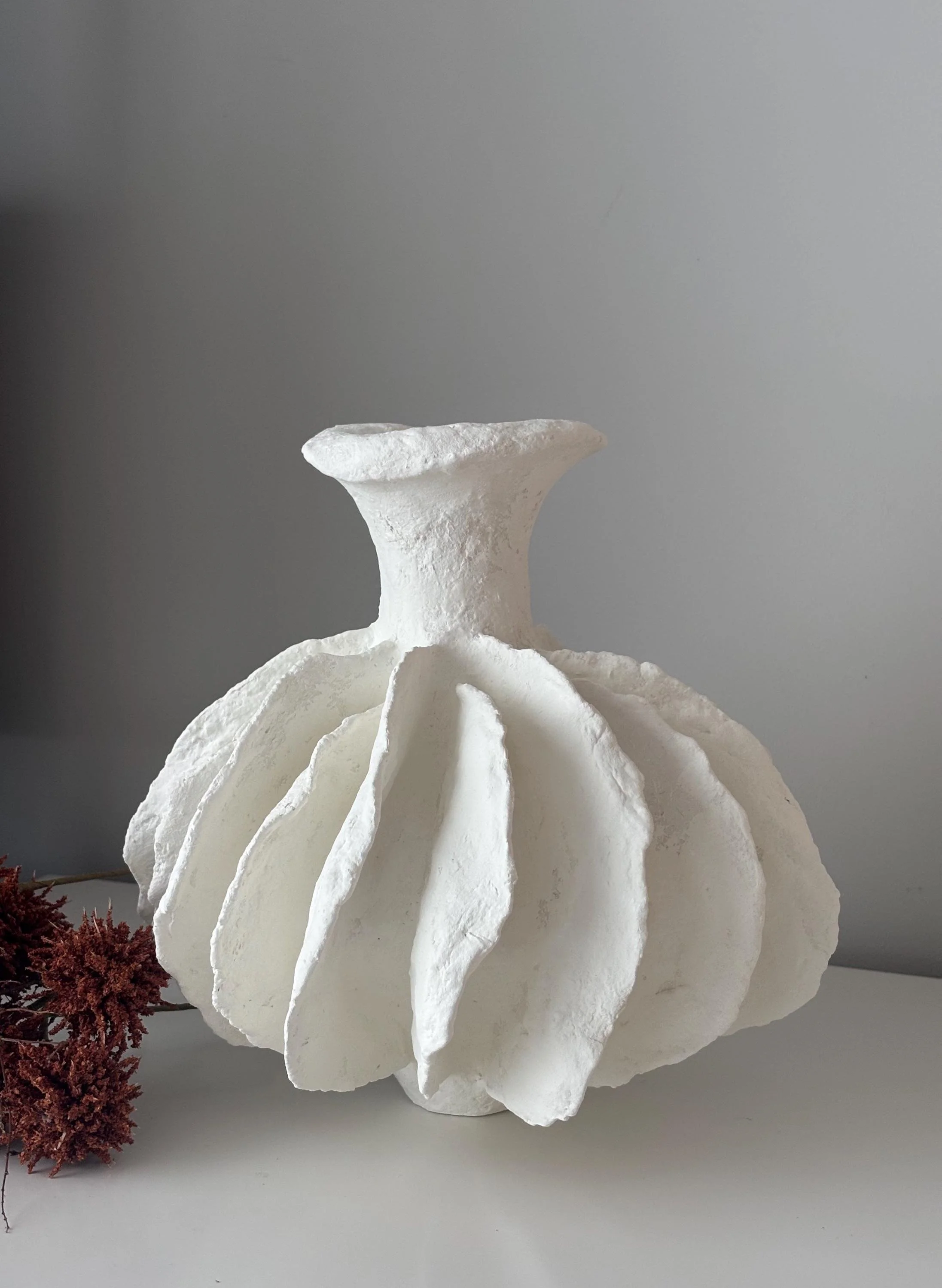 Pleated Vase N.28, handmade white pleated paper clay vase, folded form, side view. Papier Atelier London