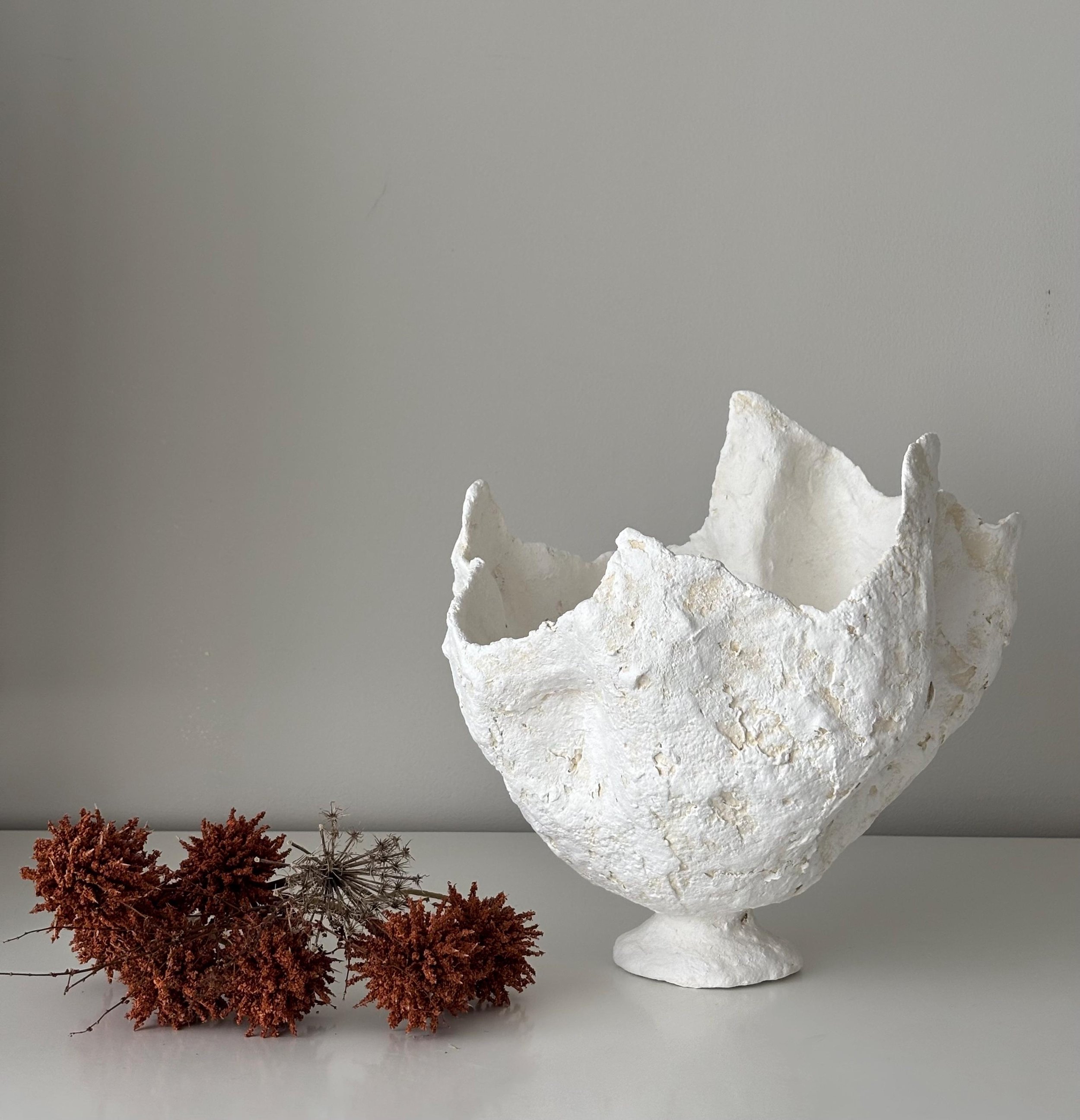 Petal Vase N.29, handmade white paper clay vase, wavy petal-like rim, side view. Papier Atelier London