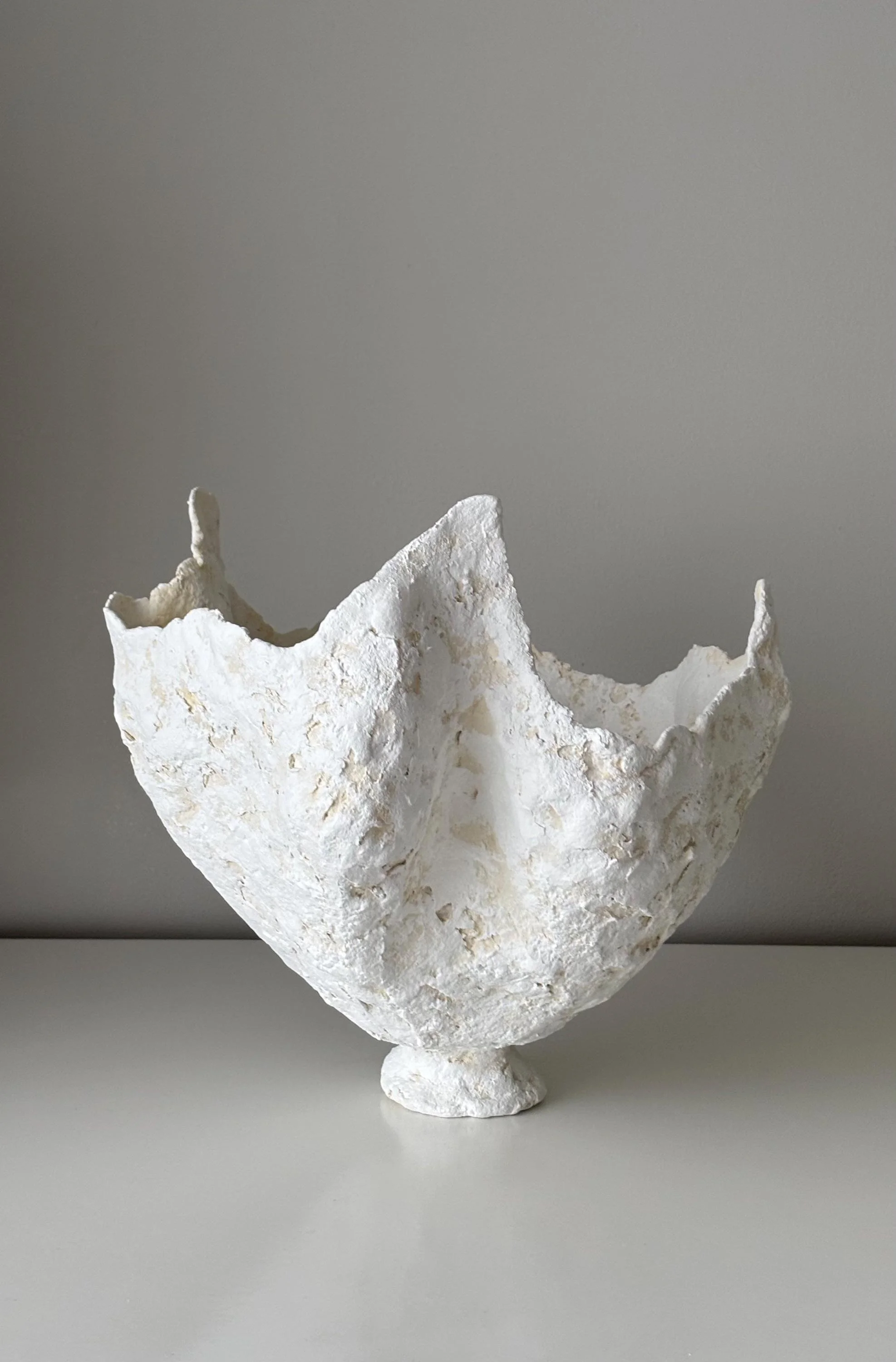 Petal Vase N.29, handmade white paper clay vase, wavy petal-like rim, in a room setting. Papier Atelier London