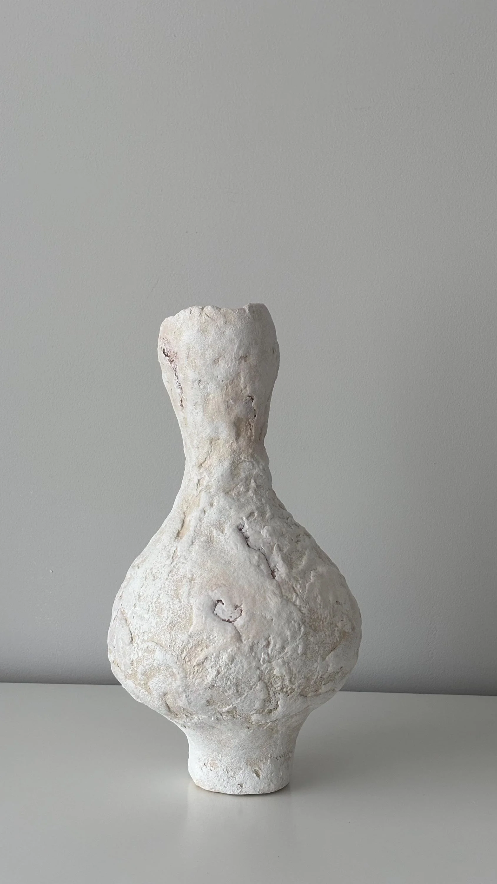 Tall Vase N.31, handmade tall paper clay vase, flared opening and relief, in a room setting. Papier Atelier London