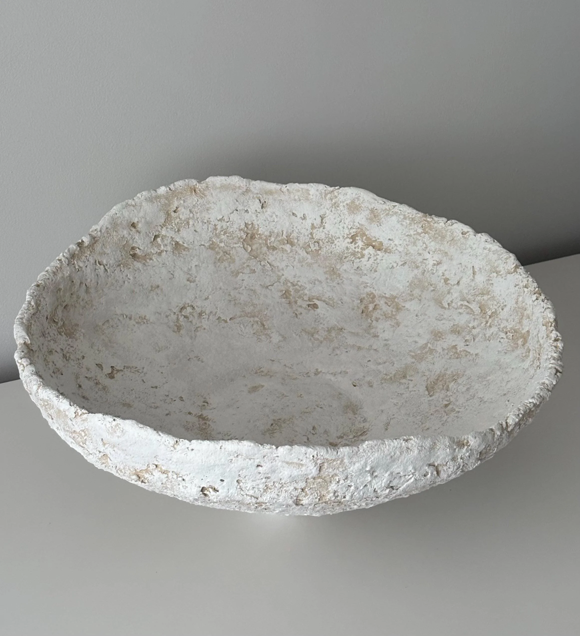 Wide Bowl N.32, handmade white paper clay bowl, on a narrow foot, in a room setting. Papier Atelier London