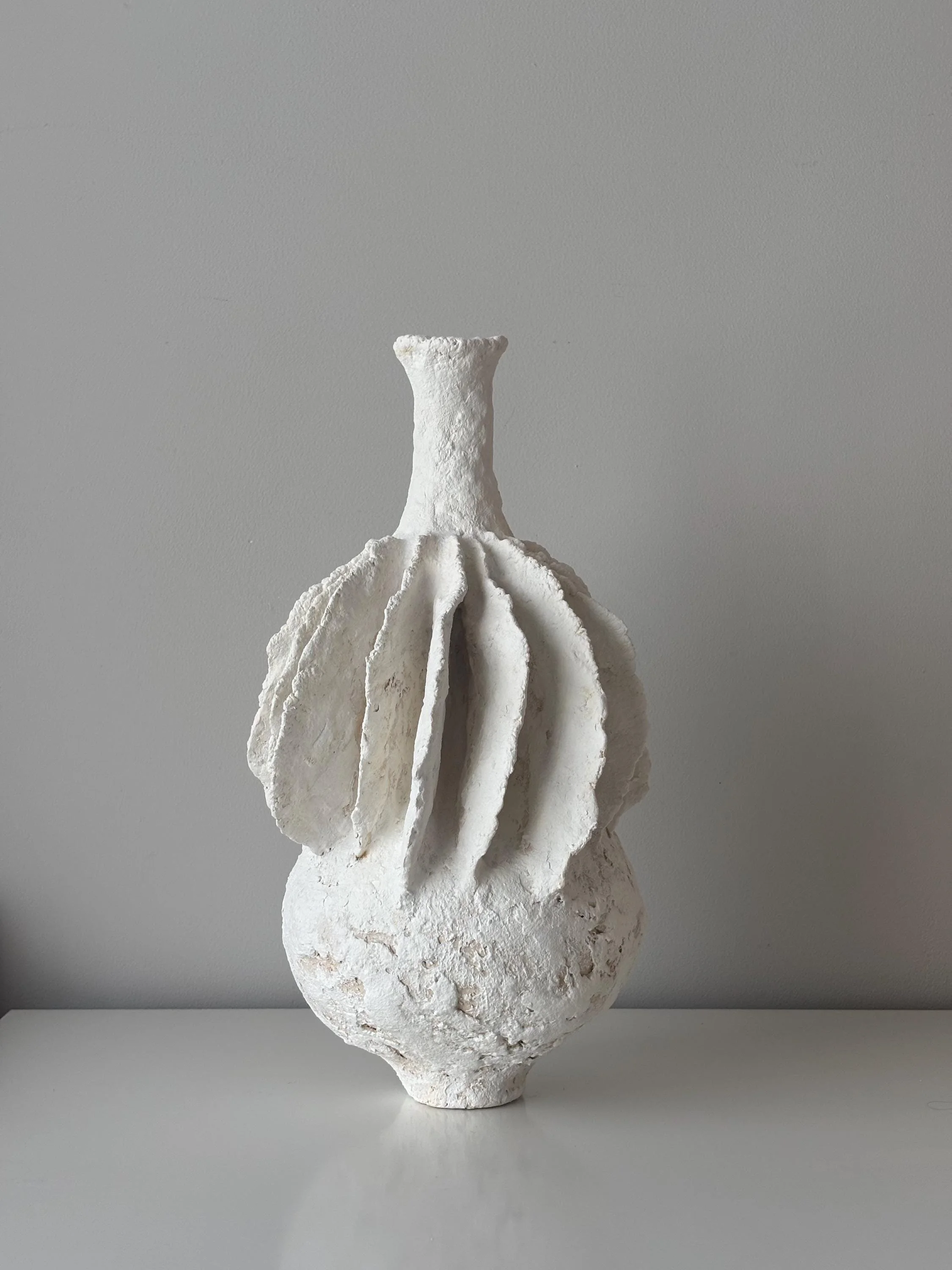 Pleated Vase N.40, handmade tall white pleated paper clay vase, folded fins, front view. Papier Atelier London