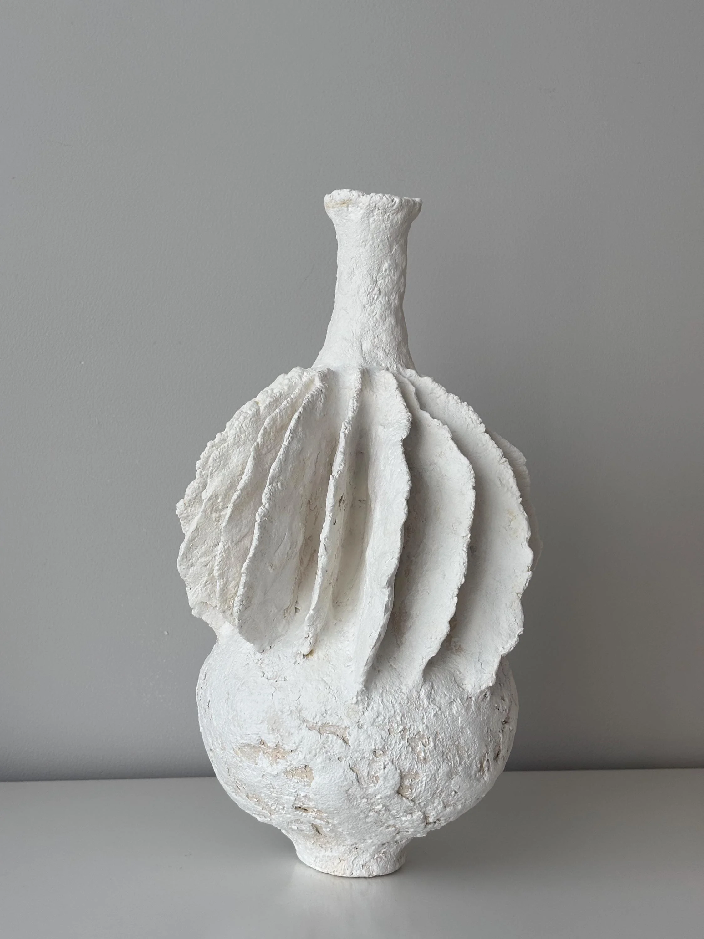 Pleated Vase N.40, handmade tall white pleated paper clay vase, folded fins, side view. Papier Atelier London